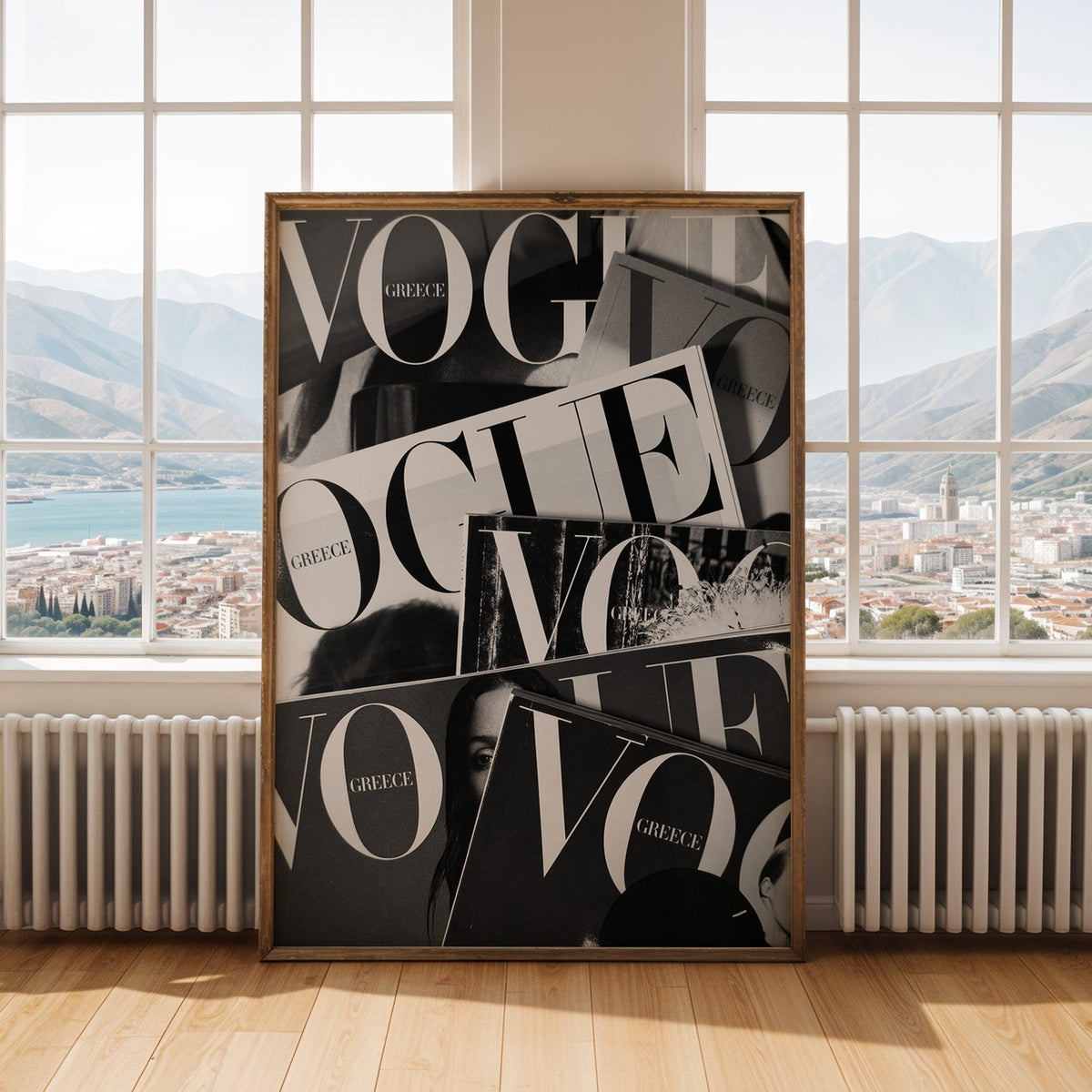 Overlapping magazine covers with giant lettering print shown in an antique gold frame by tall windows with a sea view