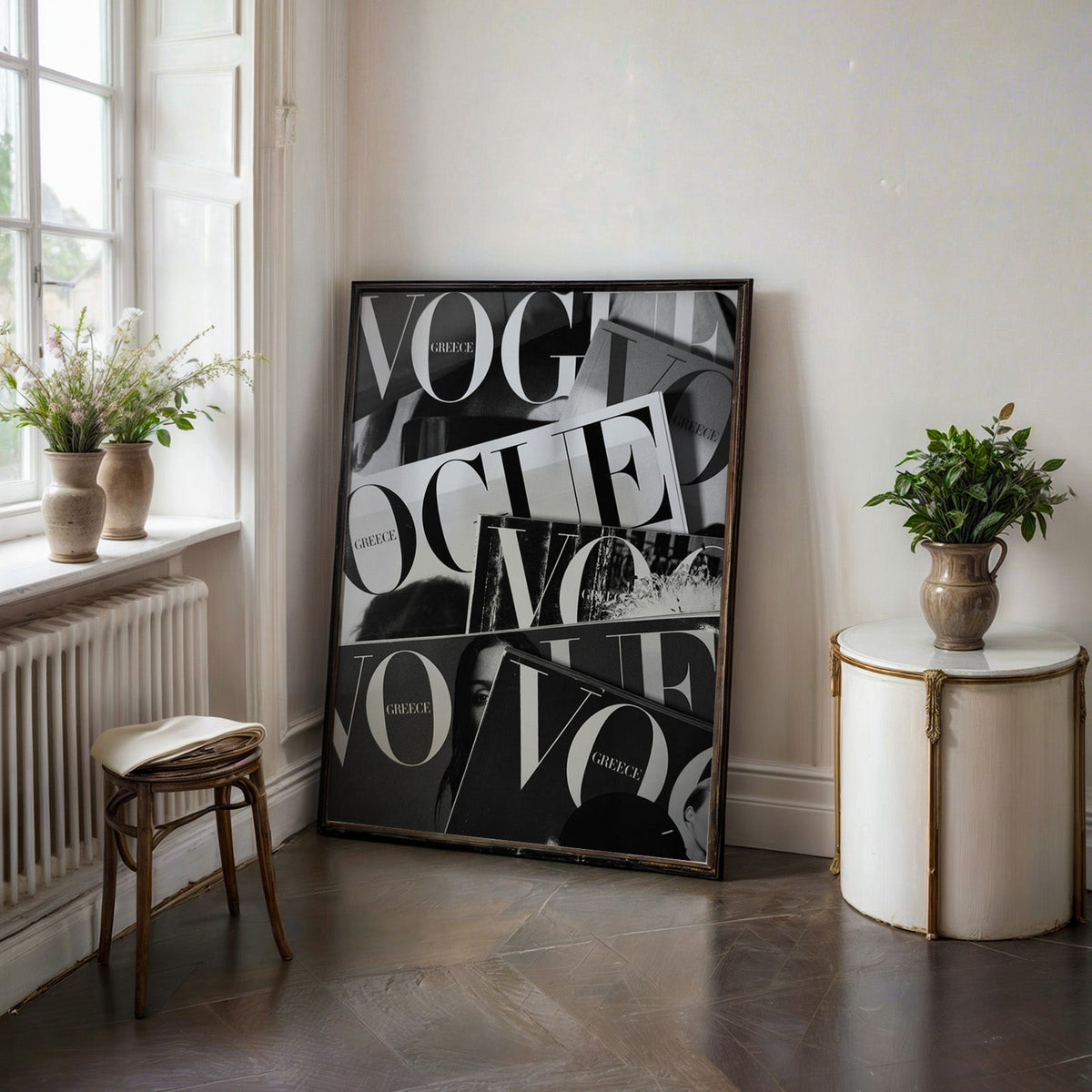 Overlapping magazine covers with giant lettering print in a black frame on a dark stone floor beside a white side table