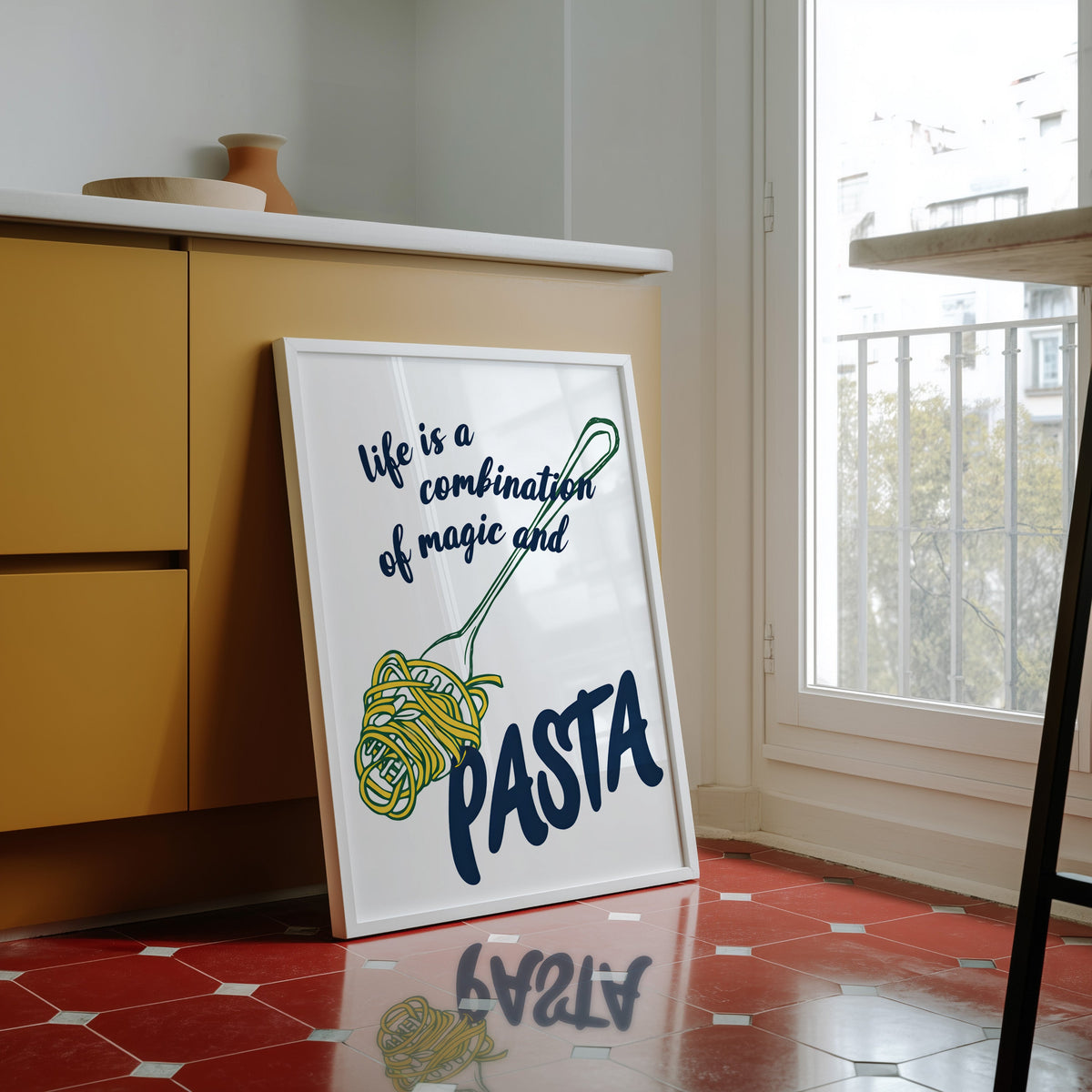 Magic and Pasta print in a white frame against yellow cabinets on a red tiled floor
