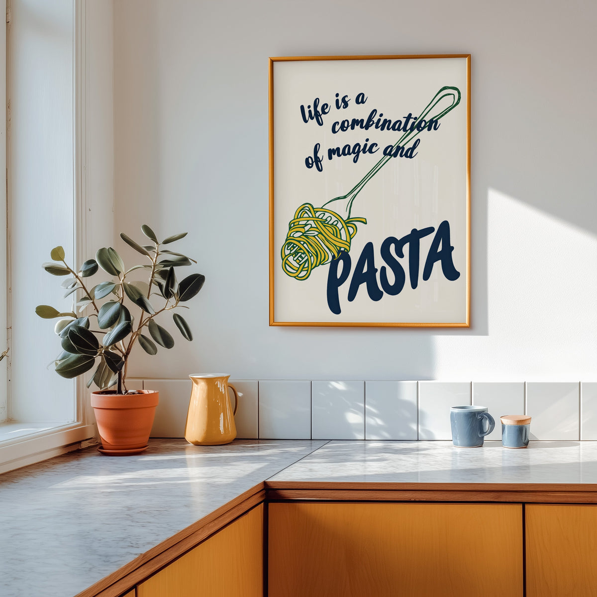 Magic and Pasta print shown in a gold frame above a marble counter with a yellow ceramic jug