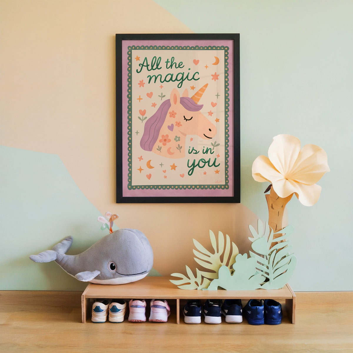 Magic is in you unicorn nursery print in a black frame on a mint and peach wall above a whale plush