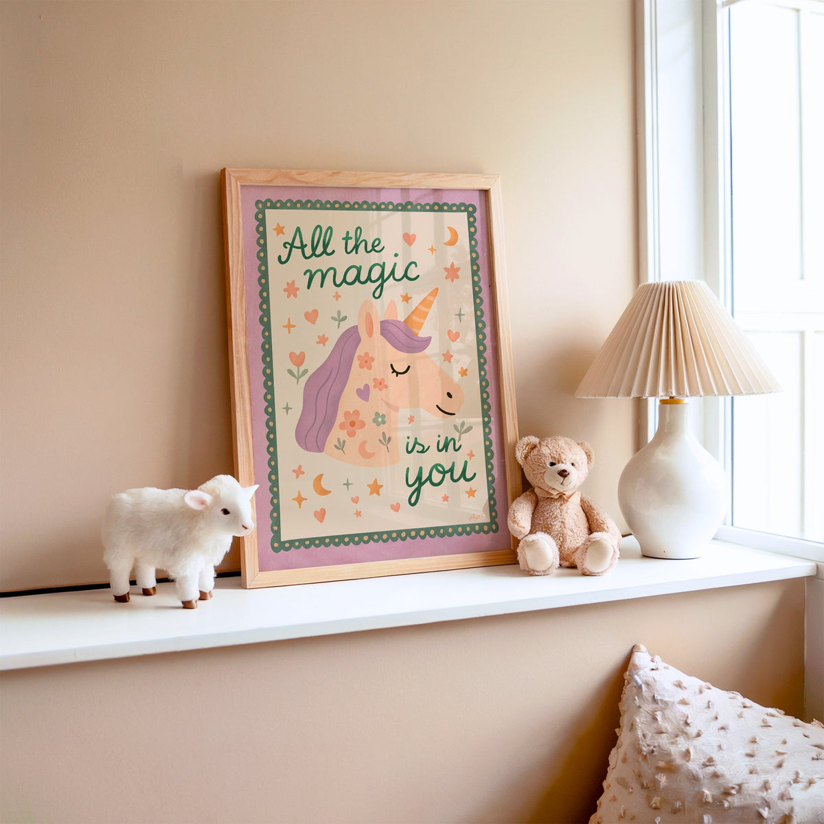 Magic is in you unicorn nursery print in an oak frame on a window ledge with a toy lamb and teddy