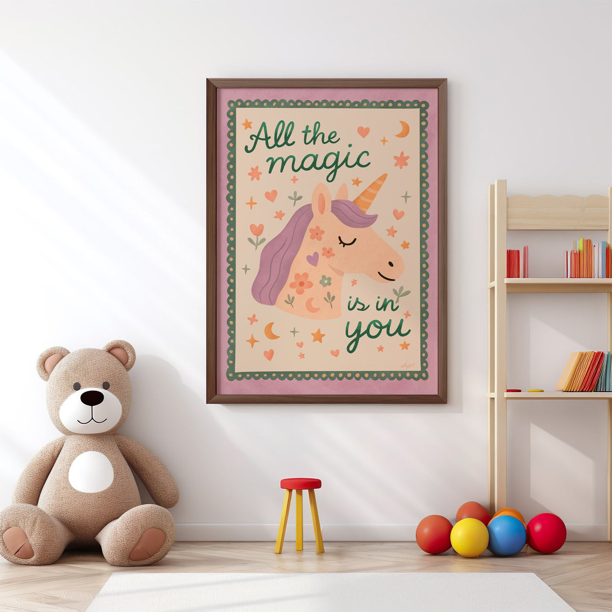 Magic is in you unicorn nursery print in a walnut frame above a big teddy bear by a bookshelf