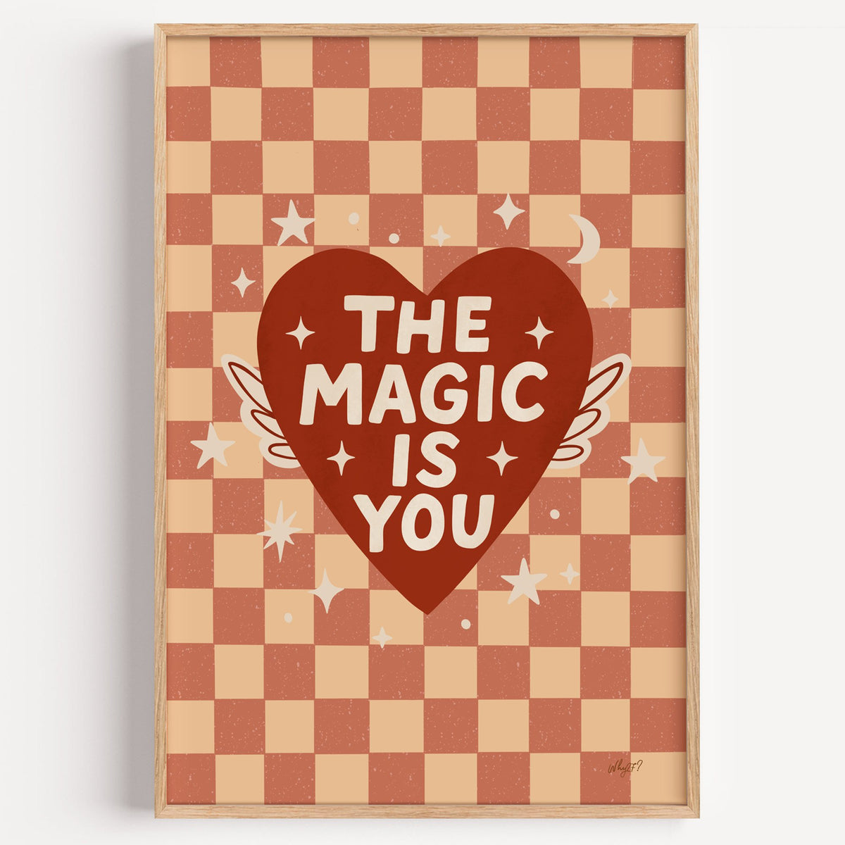 The magic is you winged heart nursery print in a light oak frame on a plain white wall