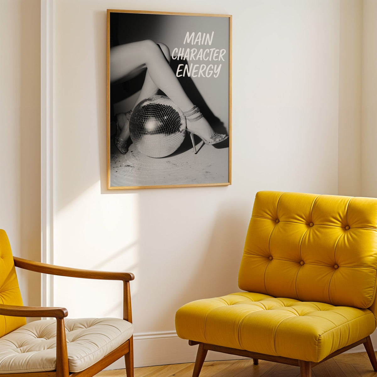 Crossed legs in heels beside disco ball print shown in a gold frame above a mustard yellow tufted armchair