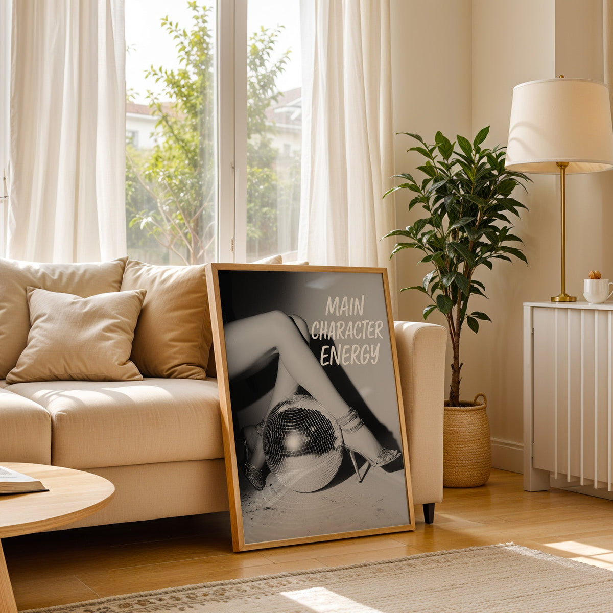 Crossed legs in heels beside disco ball print in a light oak frame leaning on a cream sofa beside a floor lamp