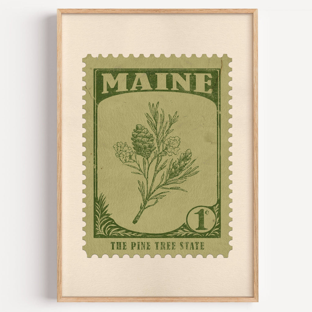 Maine state flower stamp print in olive green on sage, light oak frame on a plain white wall