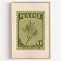 Maine state flower stamp print in olive green on sage, light oak frame on a plain white wall