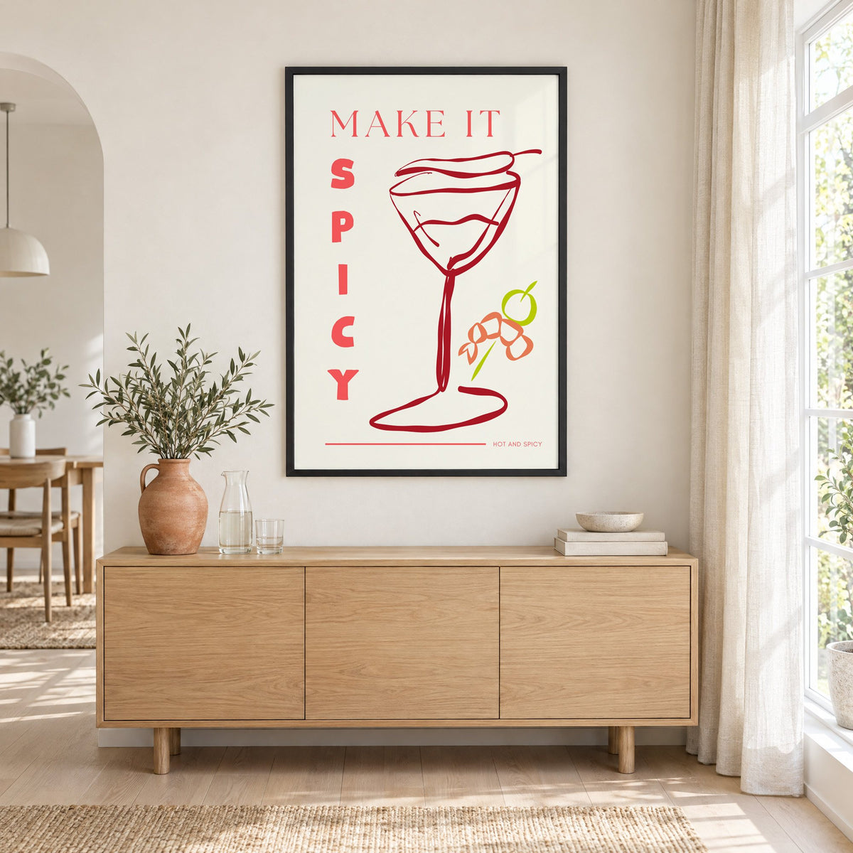 Make It Spicy martini line art print in a black frame above an oak sideboard with a terracotta vase of olive branches