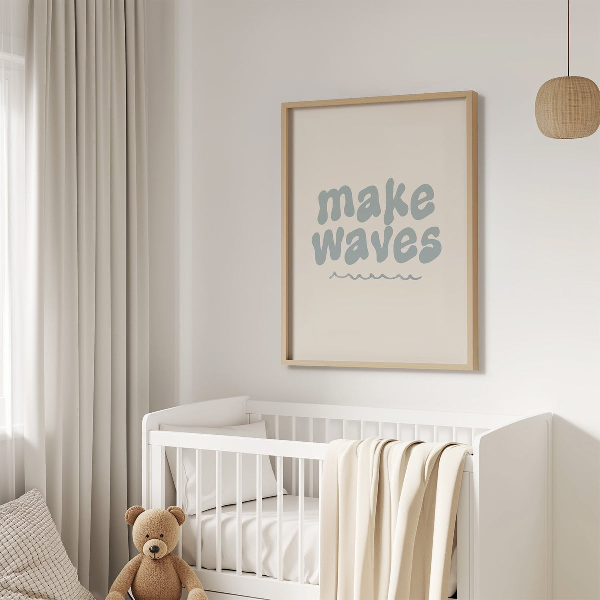Make waves typography nursery print in an oak frame above a white crib with a teddy bear
