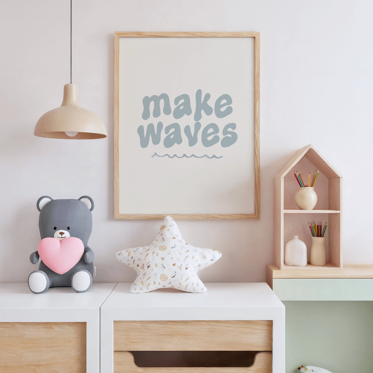 Make waves typography nursery print in an oak frame above a white dresser with a star pillow and house shelf