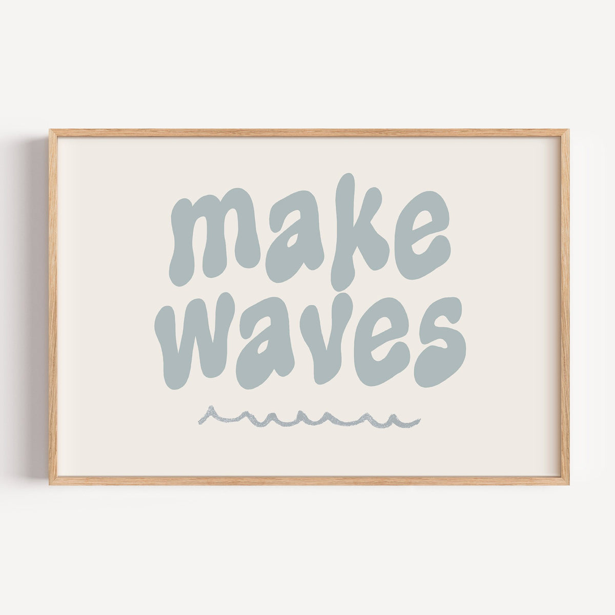 Landscape make waves typography nursery print in a light oak frame on a plain white wall
