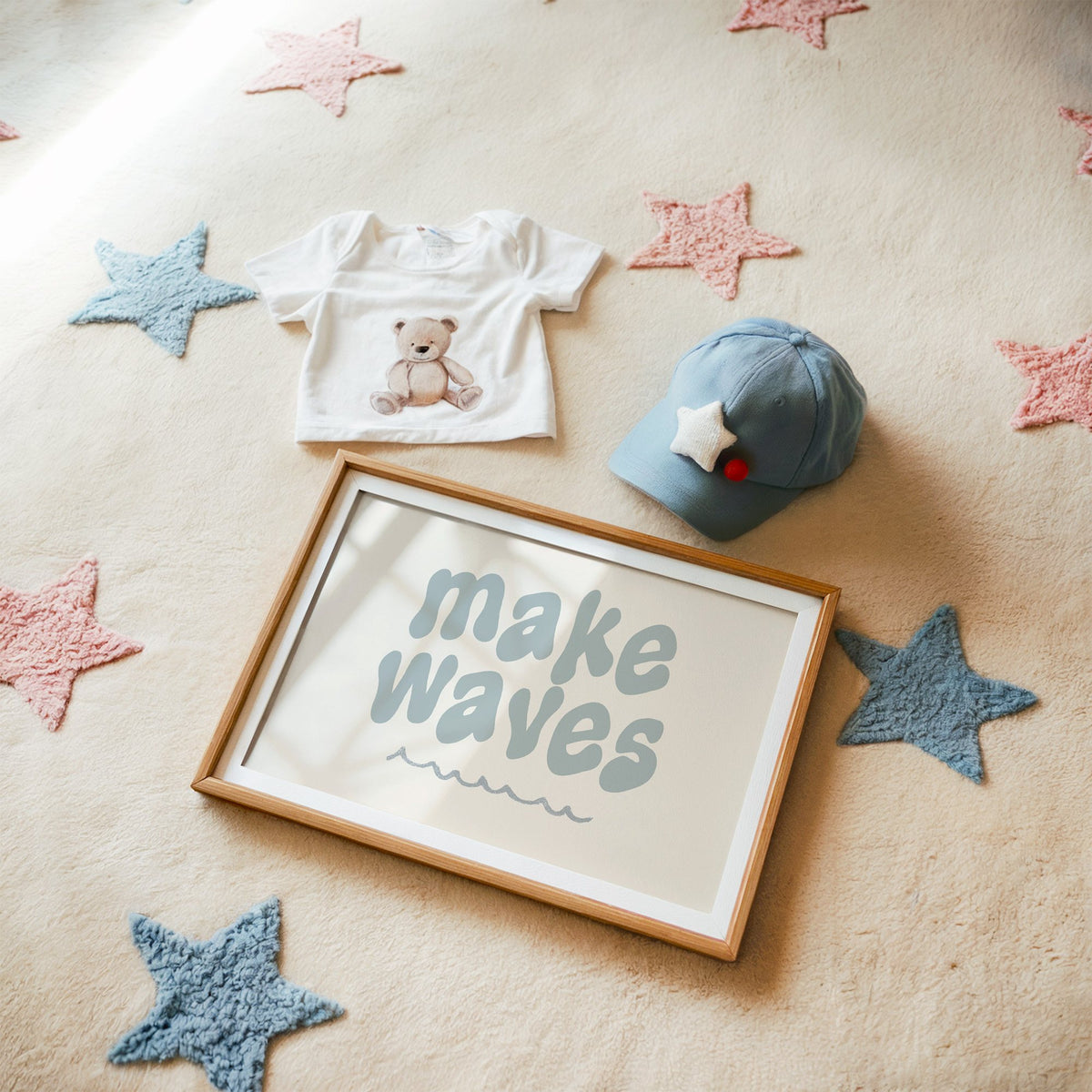 Landscape make waves typography nursery print in a matted oak frame on a star rug with a baby tee