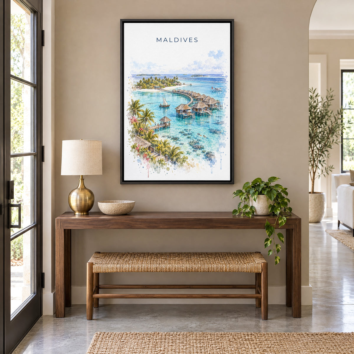 Maldives watercolor print as a black floater canvas above a walnut console and woven bench in an entryway