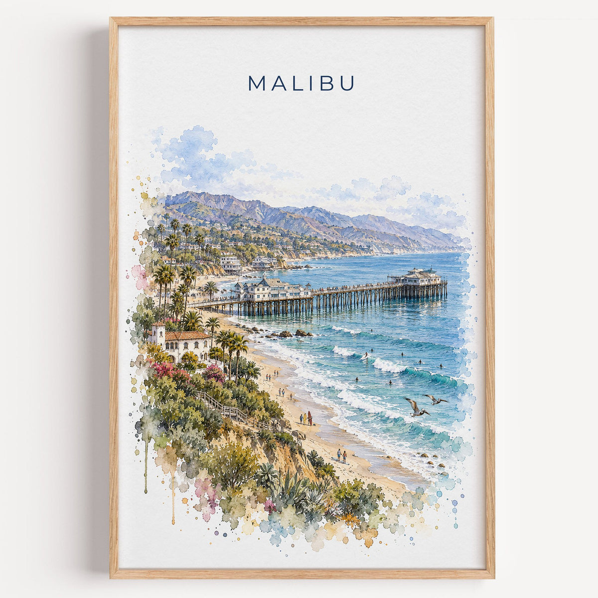 Malibu watercolor print in a light oak frame on a plain white wall