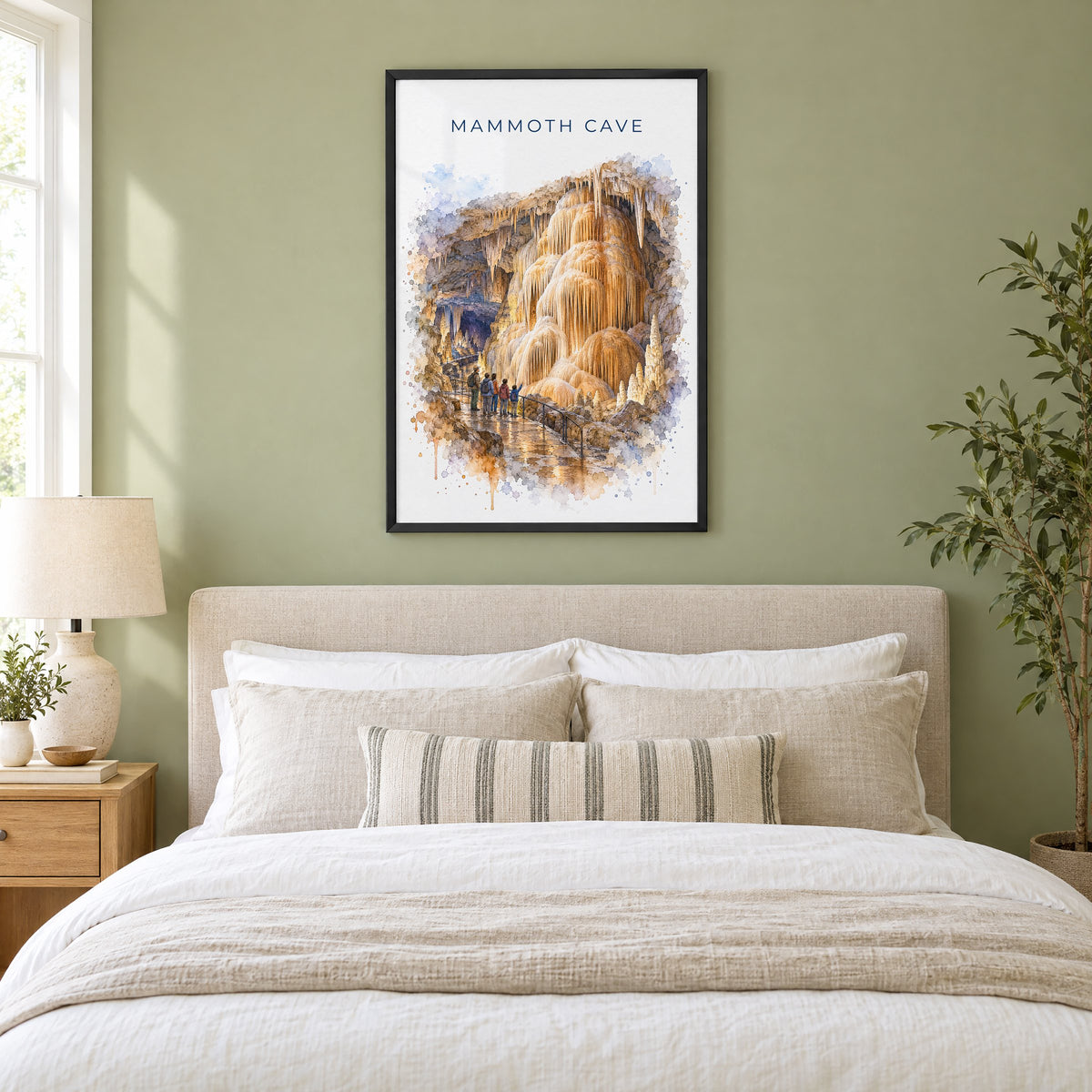 Mammoth Cave National Park watercolor print in a black frame above an upholstered headboard in a sage green bedroom