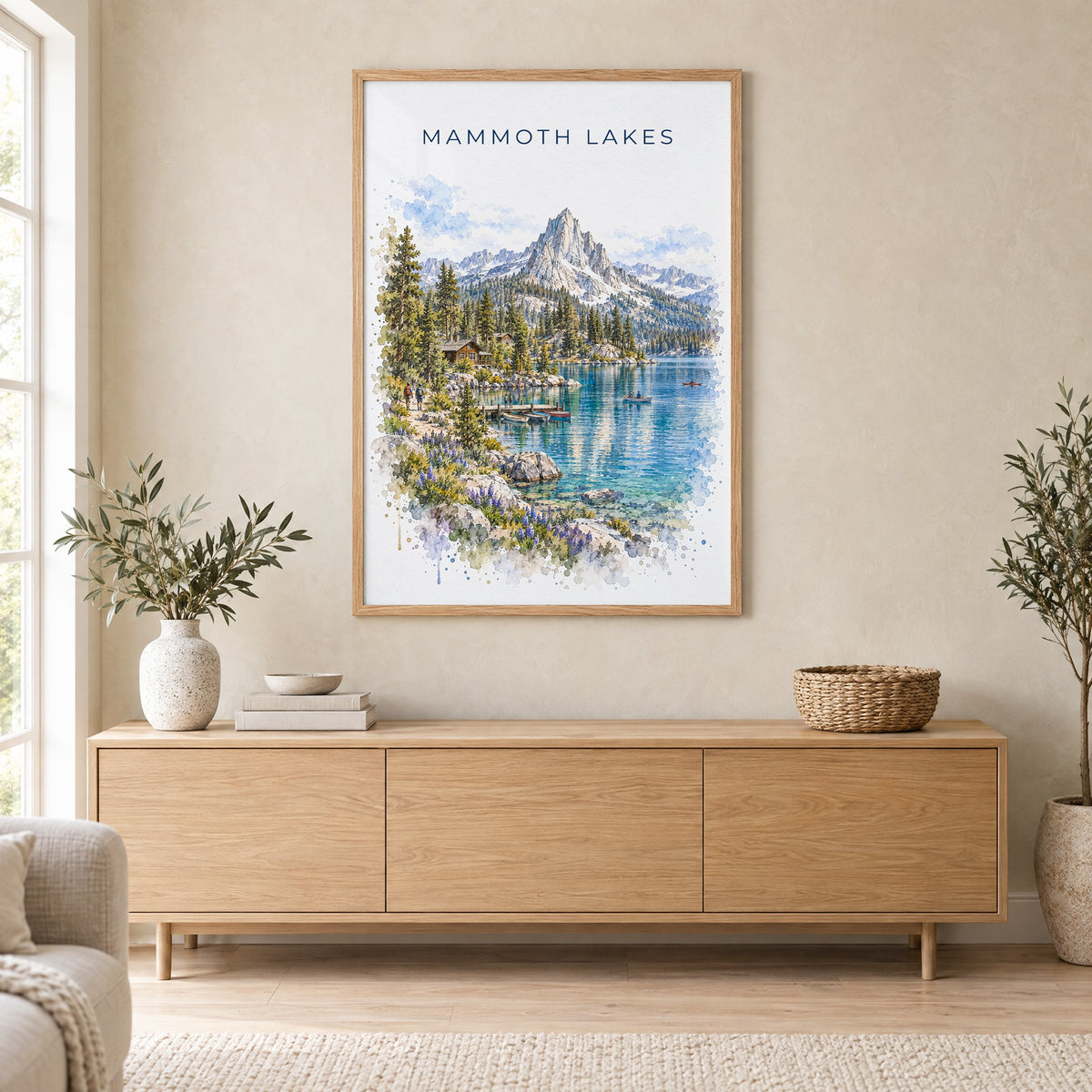 Mammoth Lakes watercolor print in an oak frame above a light wood sideboard in a Scandinavian living room