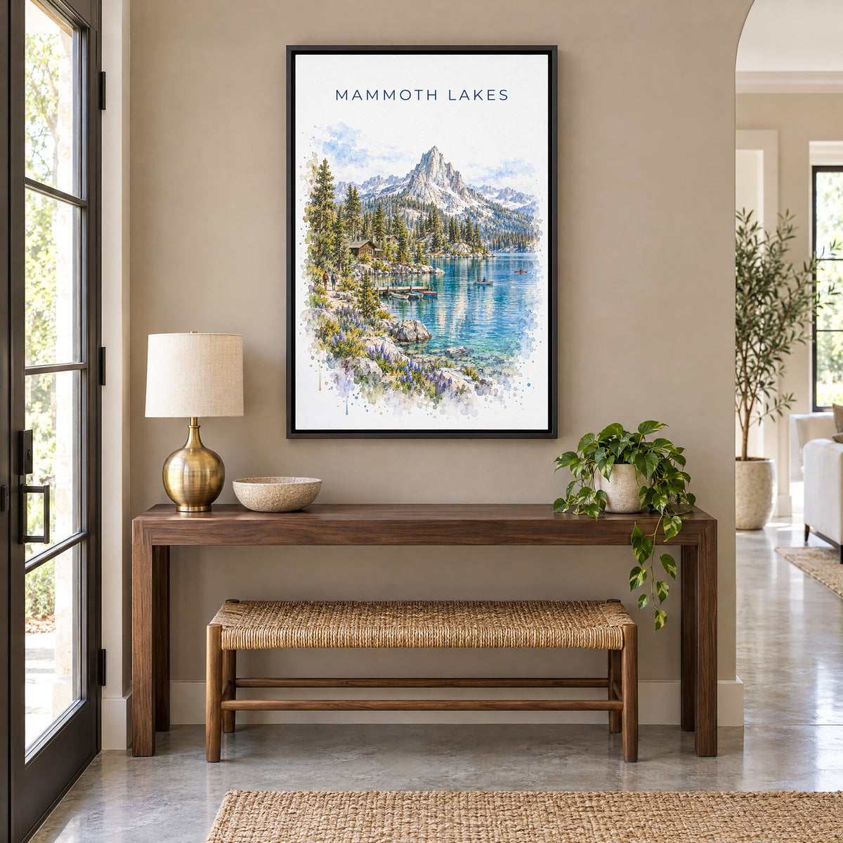 Mammoth Lakes watercolor print as a black floater canvas above a walnut console and woven bench in an entryway