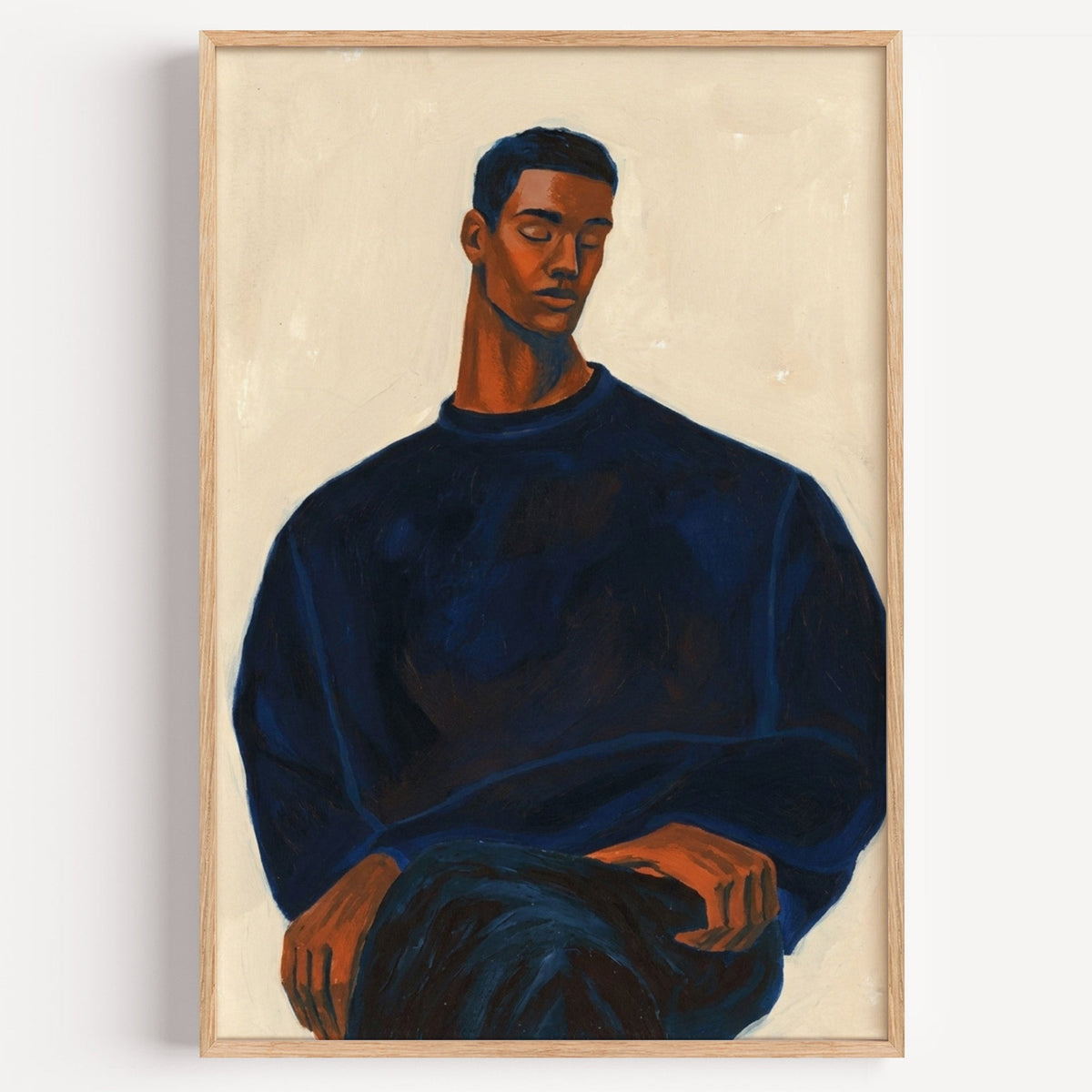 Man in navy sweater print in a light oak frame on a plain white wall