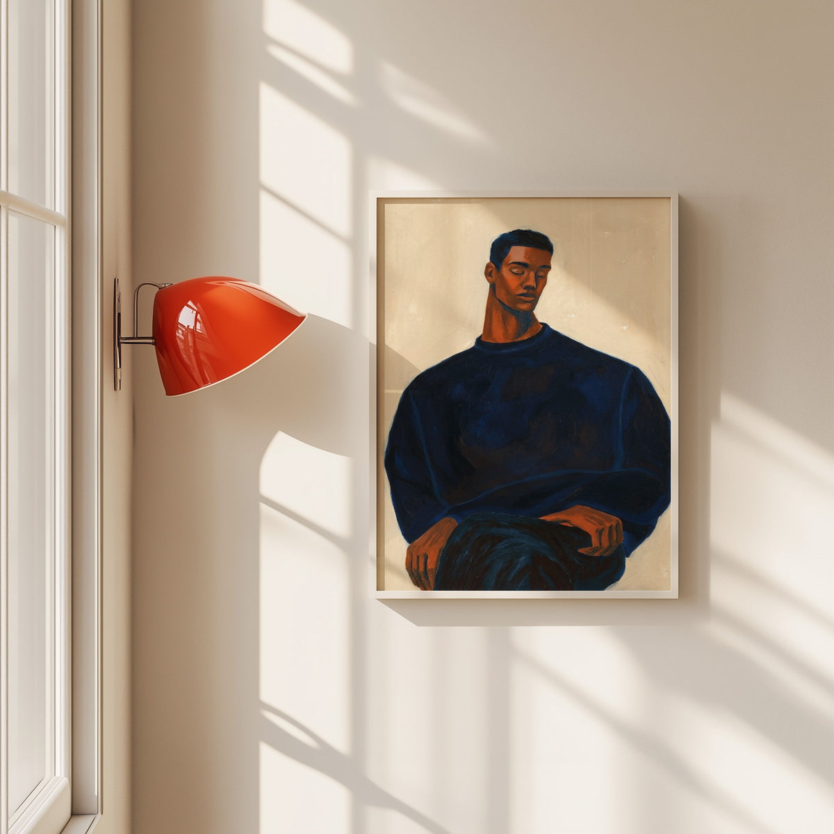 Man in navy sweater print in a white frame beside a red wall sconce