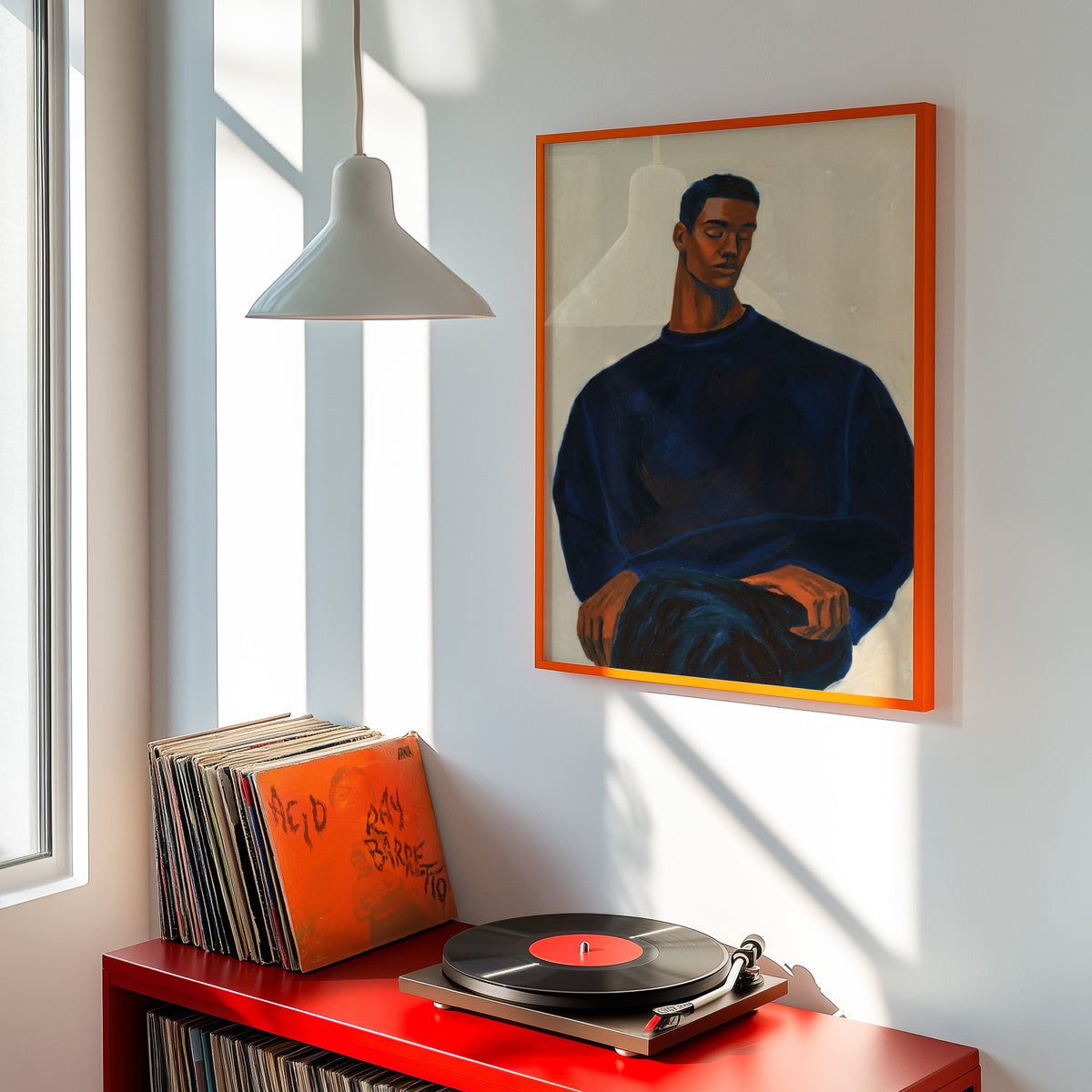Navy and terracotta portrait print shown in an orange frame above a red record cabinet and turntable
