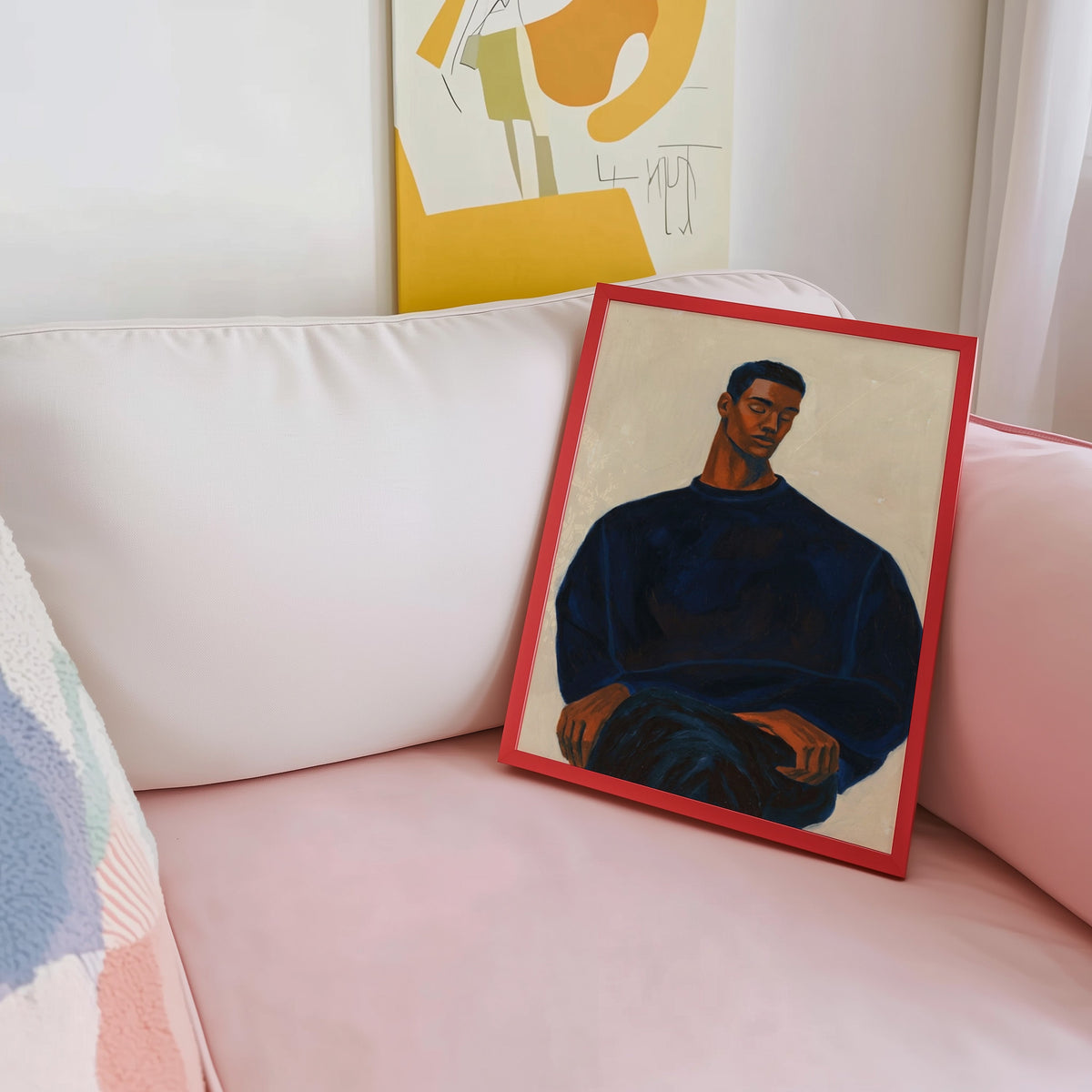 Calm figure portrait print shown in a red frame leaning on a blush pink sofa