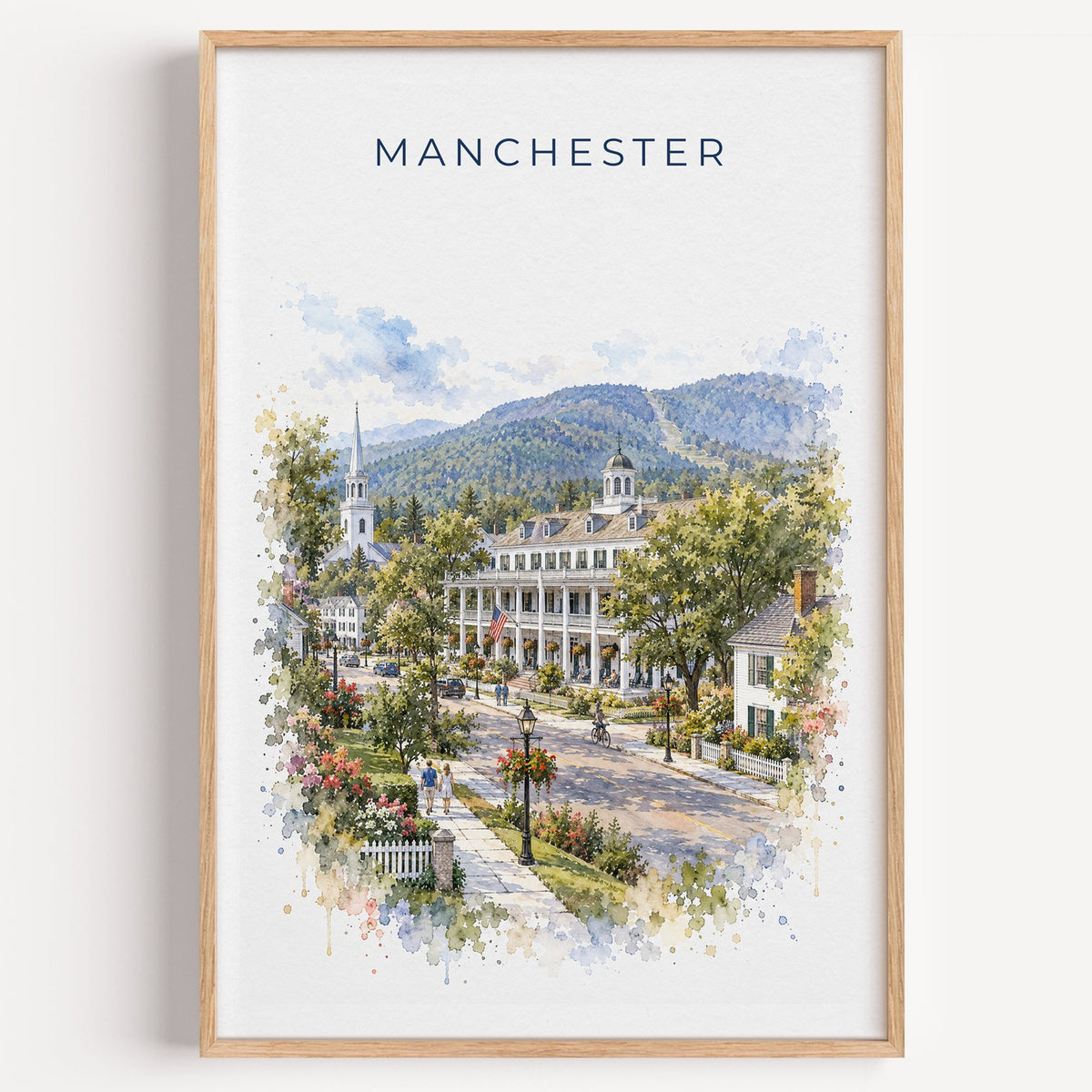 Manchester, Vermont watercolor print in a light oak frame on a plain white wall