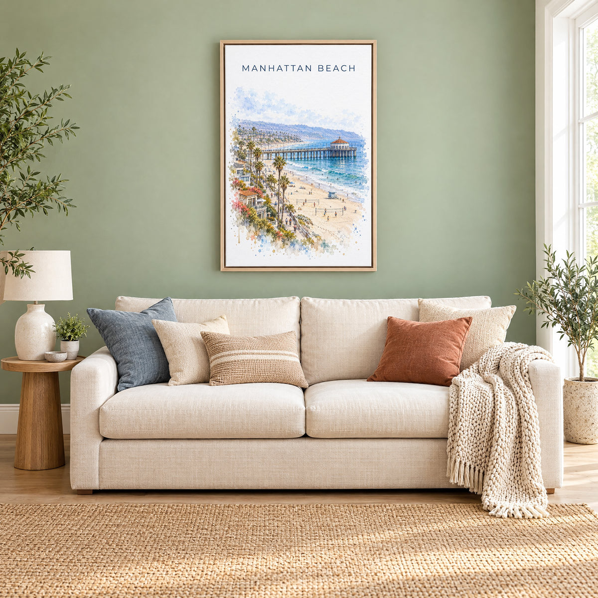 Manhattan Beach watercolor print as a natural floater canvas above a cream linen sofa on a sage green wall