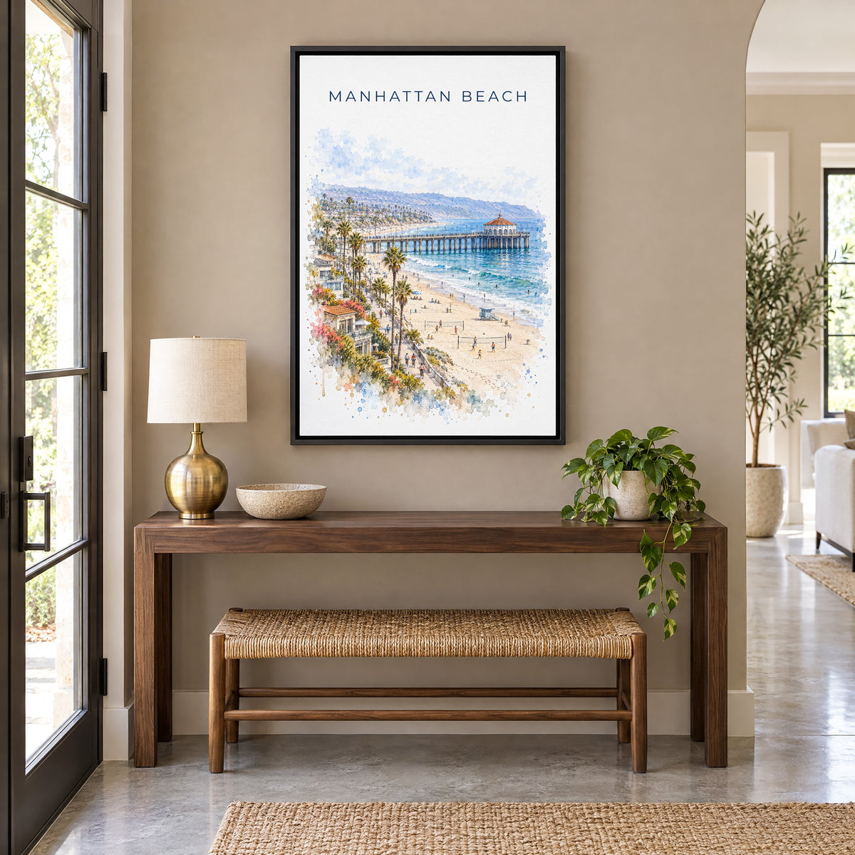 Manhattan Beach watercolor print as a black floater canvas above a walnut console and woven bench in an entryway