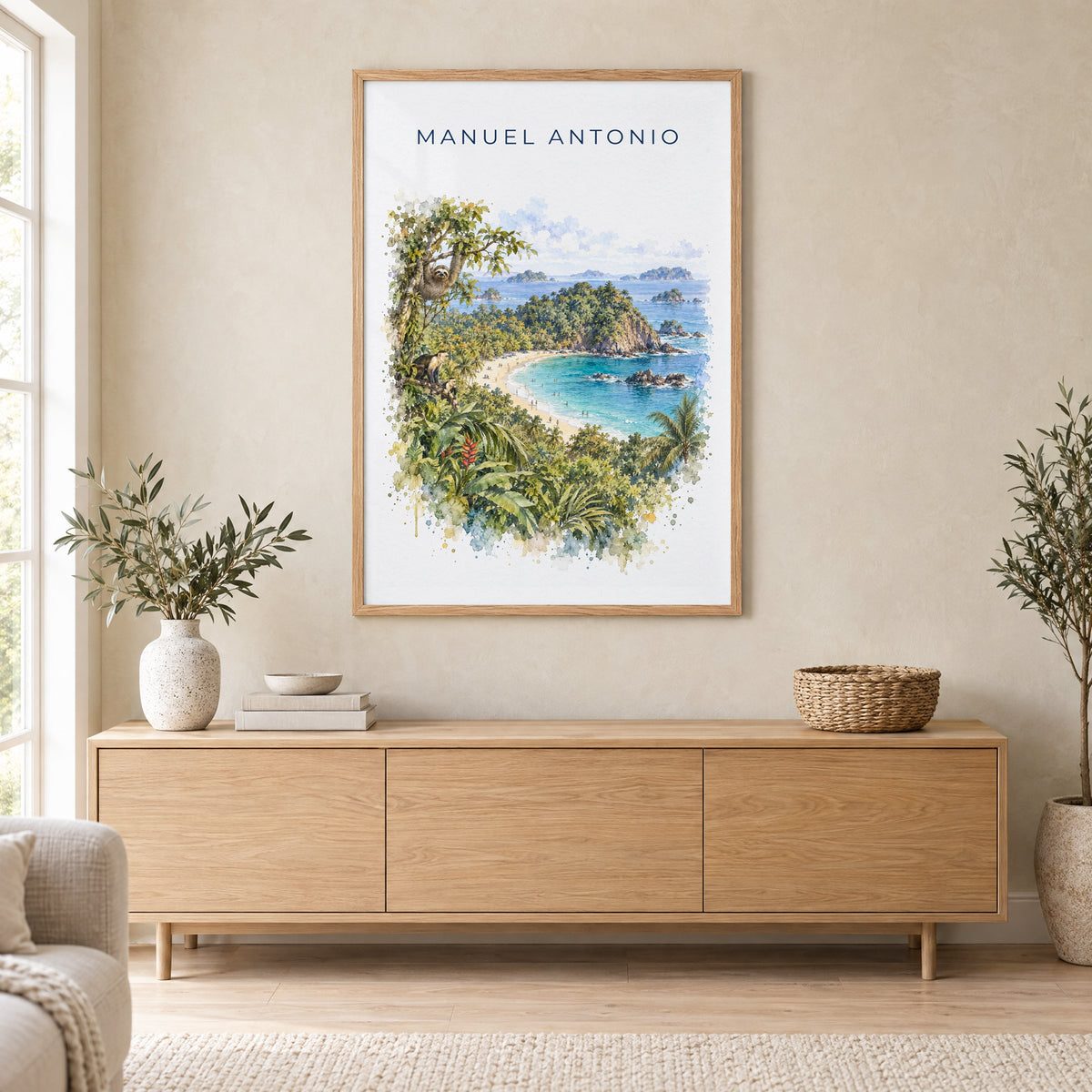 Manuel Antonio watercolor print in an oak frame above a light wood sideboard in a Scandinavian living room