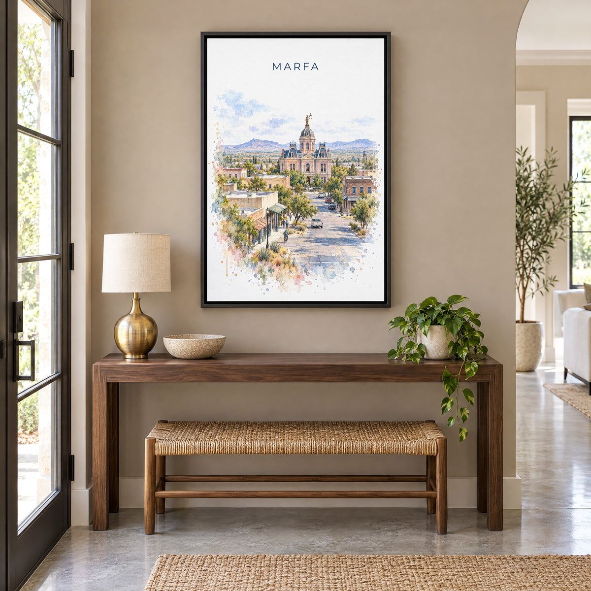 Marfa watercolor print as a black floater canvas above a walnut console and woven bench in an entryway