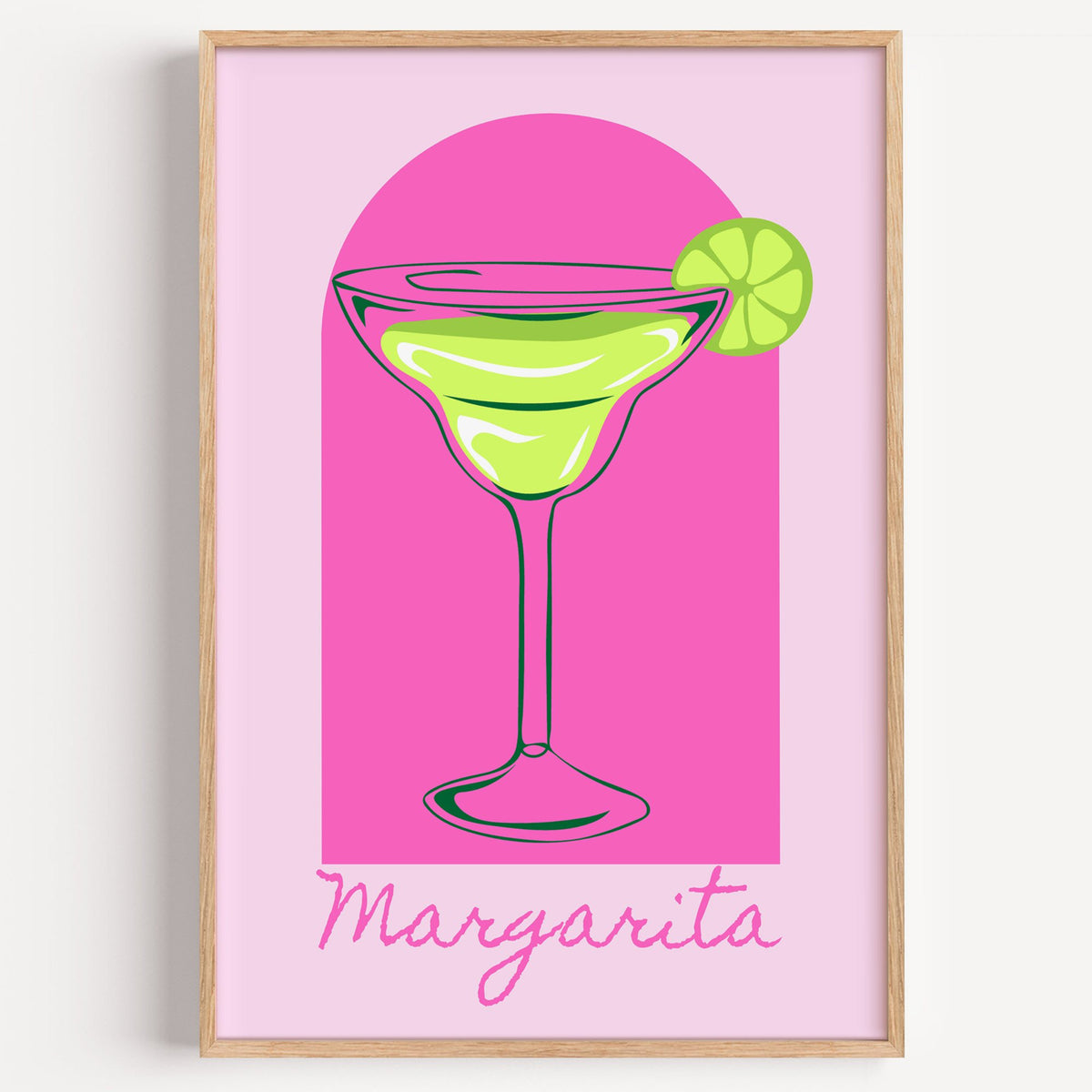 Margarita glass and lime pink arch print in a light oak frame on a plain white wall