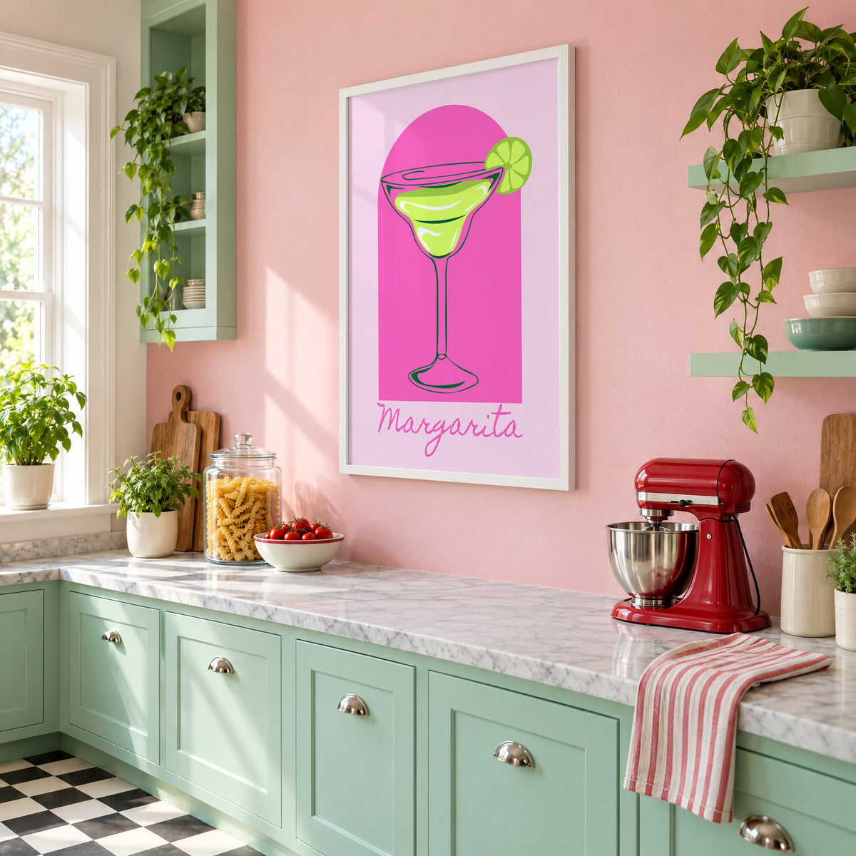 Margarita glass and lime pink arch print in a white frame on a pink wall above mint green cabinets in a retro kitchen, seen at an angle