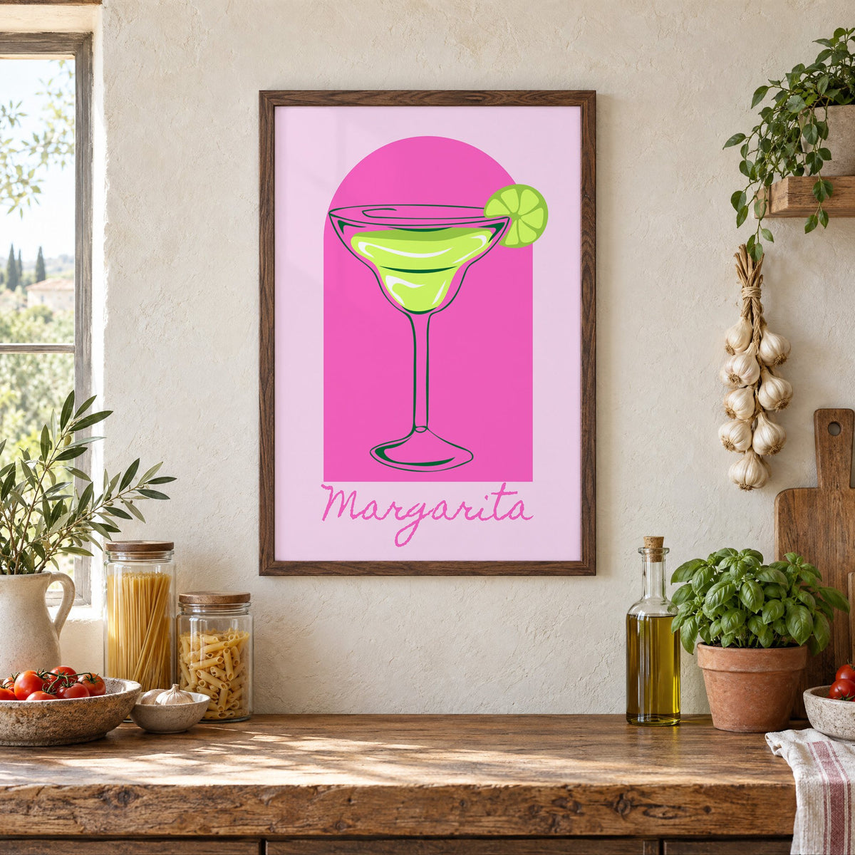 Margarita glass and lime pink arch print in a walnut frame above a rustic Italian pantry counter with pasta jars, garlic and tomatoes
