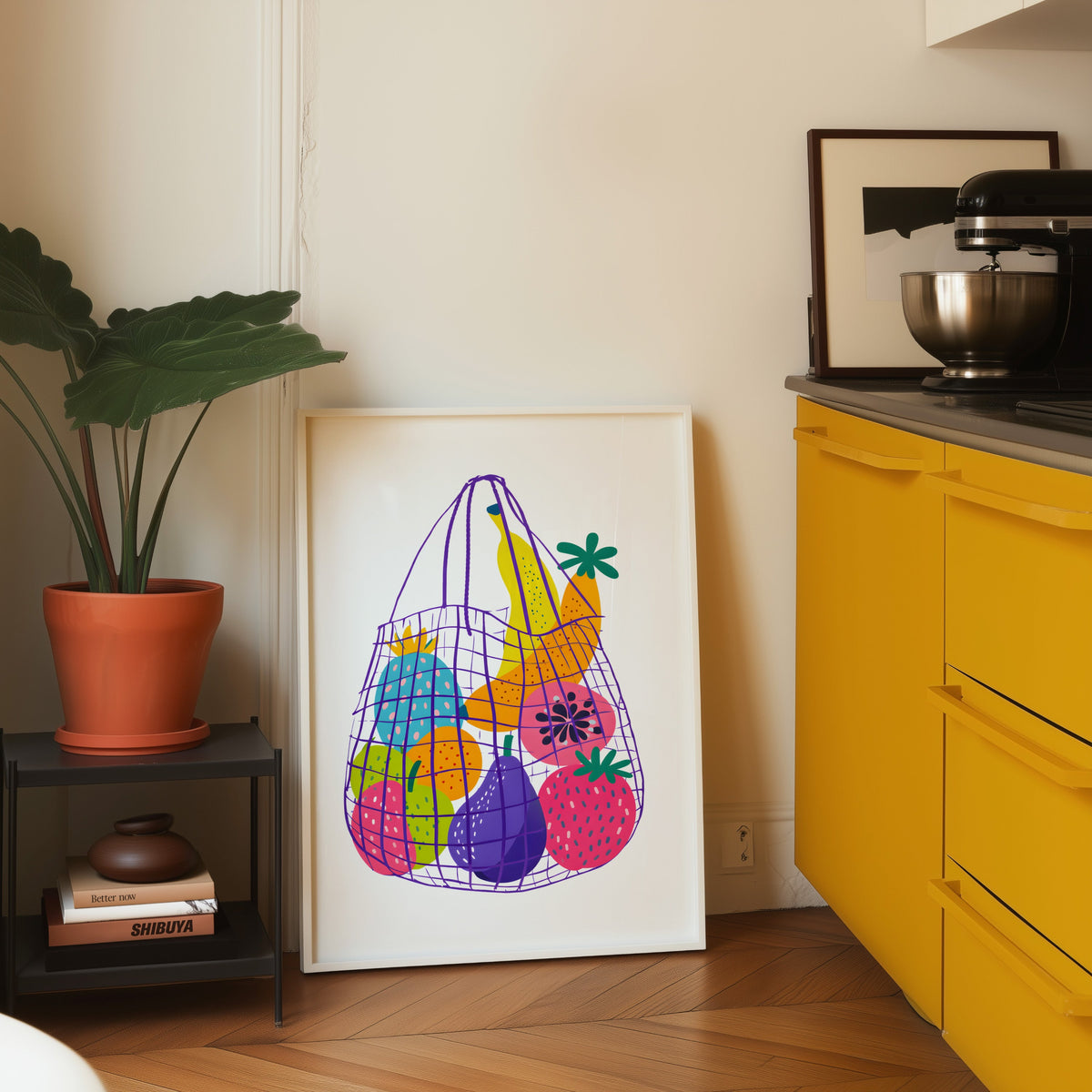 Fruit market bag print in a white frame on parquet beside a bright yellow kitchen