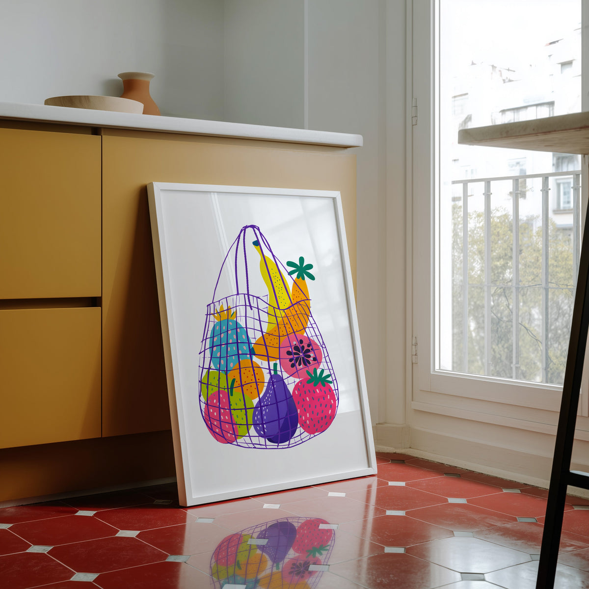 Fruit market bag print in a white frame against yellow cabinets on red tiles