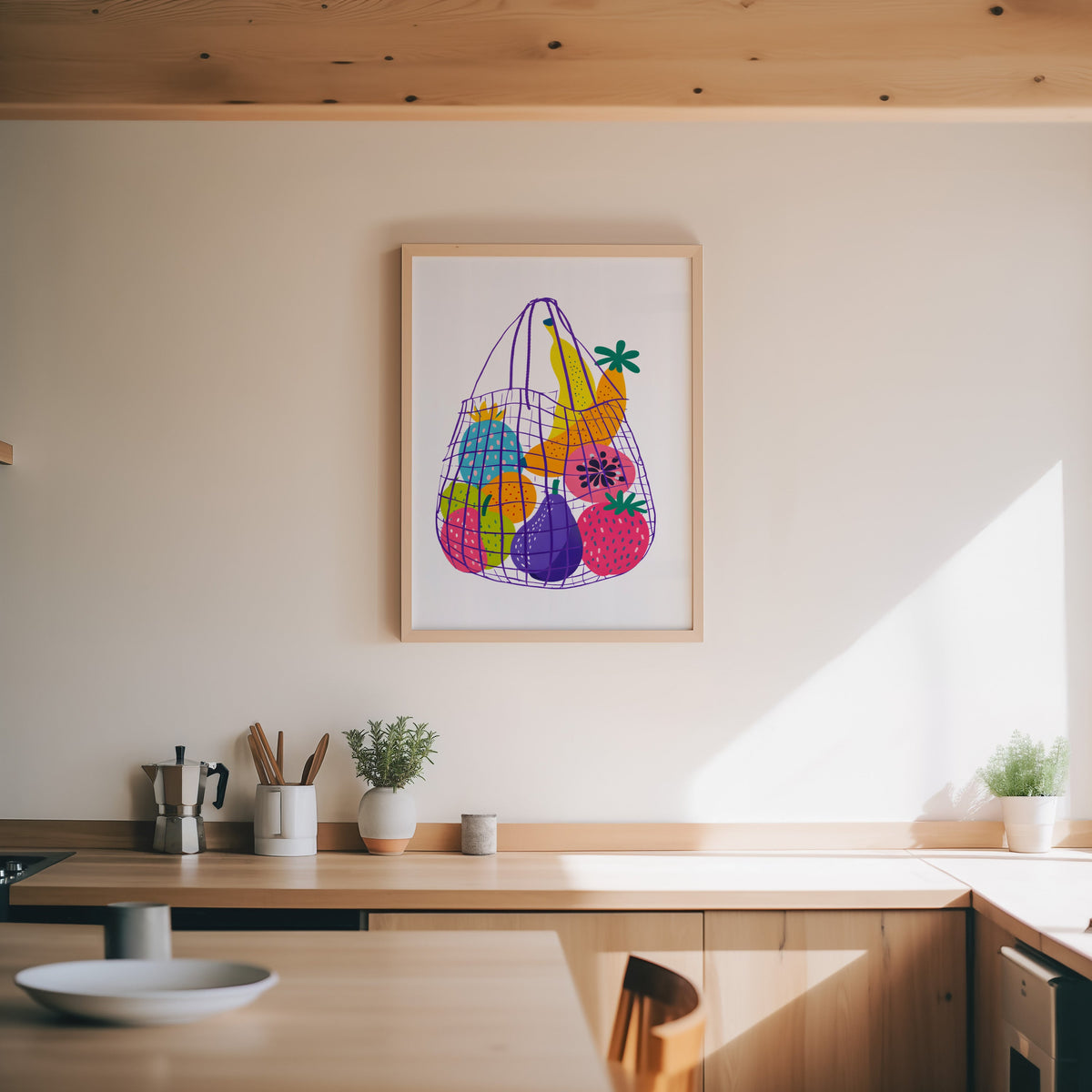Fruit market bag print in an oak frame above a wood counter with a moka pot