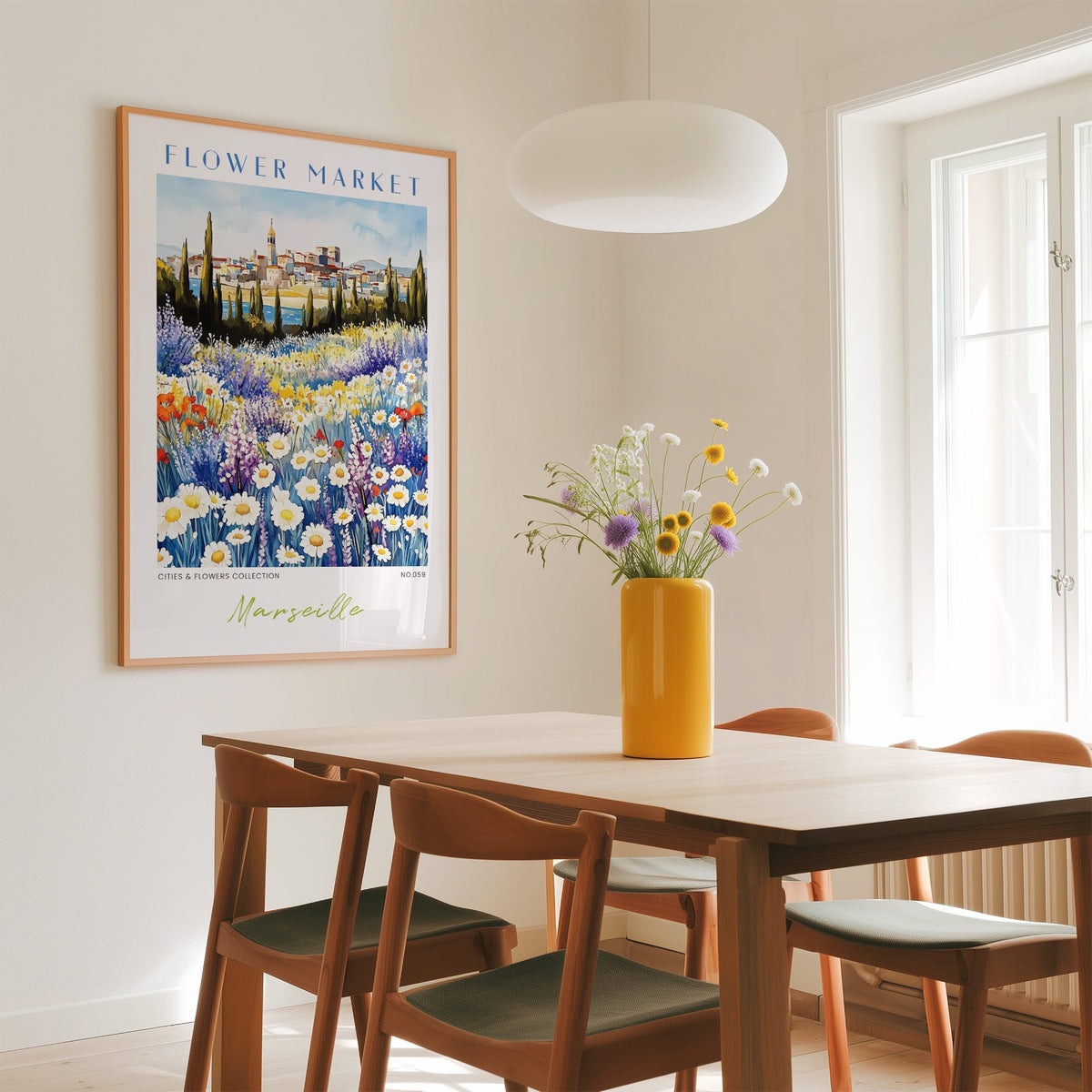 Marseille flower market print in an oak frame above a dining table with a yellow vase and white pendant light