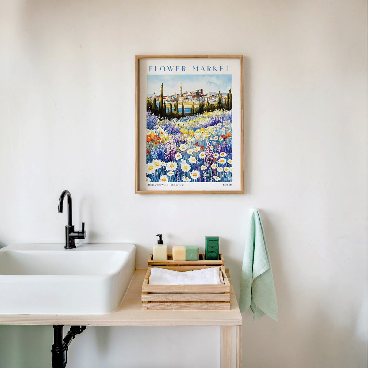 Marseille flower market print in an oak frame above a white bathroom sink with folded towels