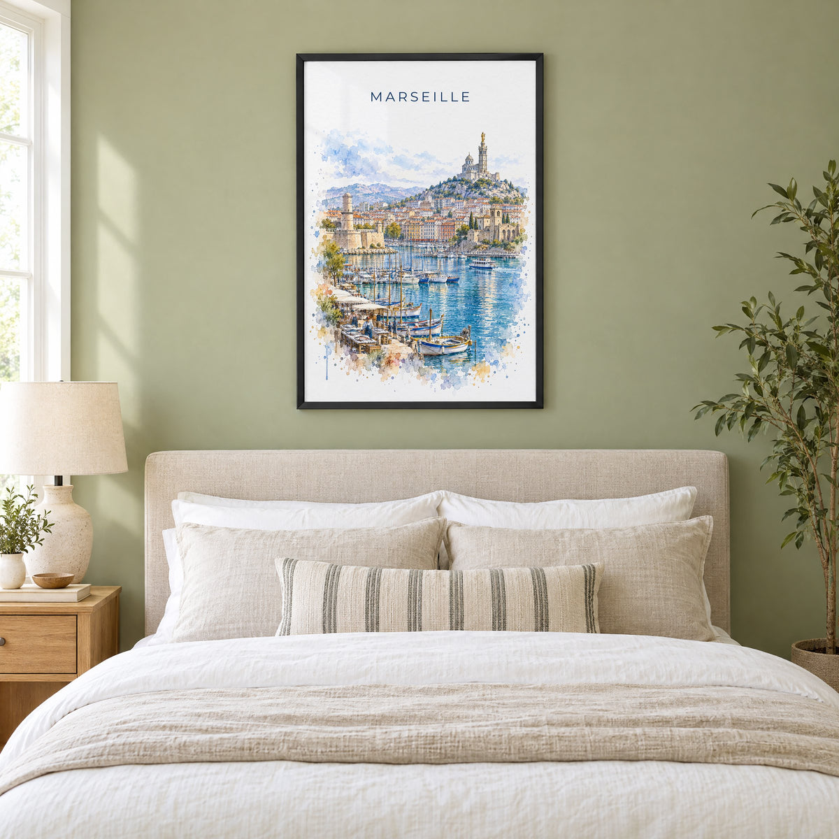 Marseille watercolor print in a black frame above an upholstered headboard in a sage green bedroom