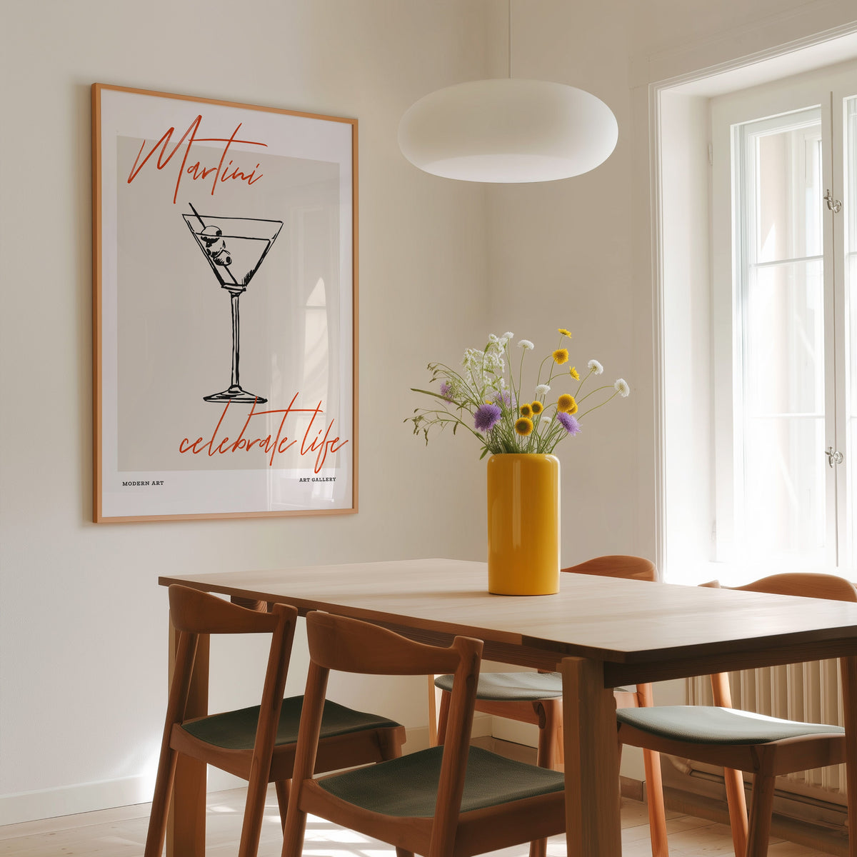 Martini Celebrate Life print in a slim oak frame above a dining table