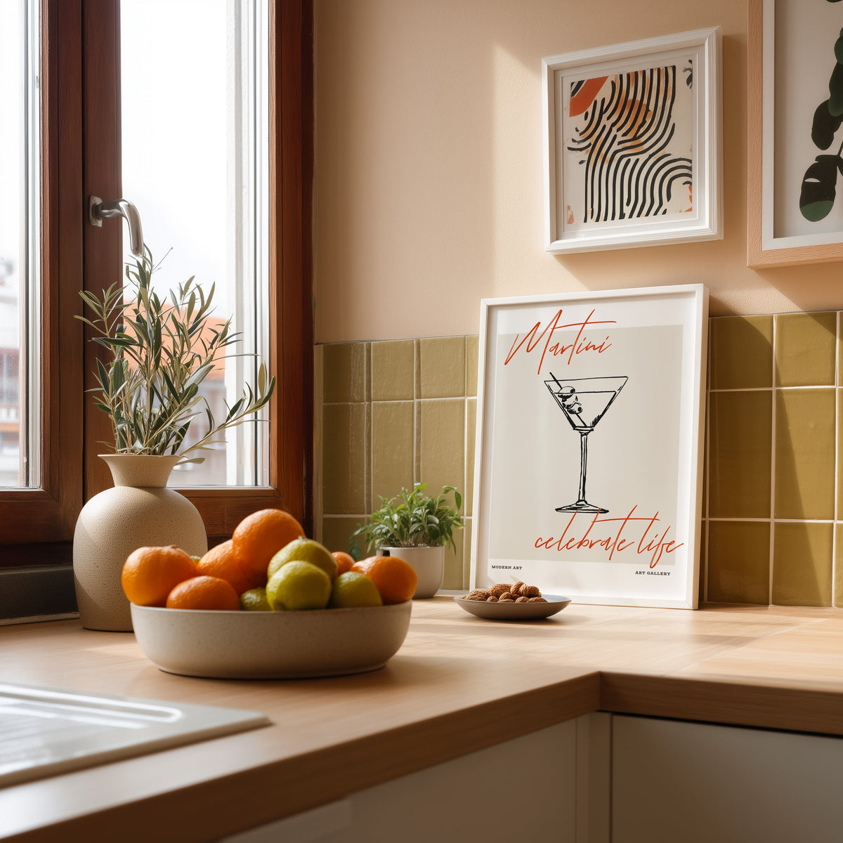 Martini Celebrate Life print in a white frame against olive green kitchen tiles