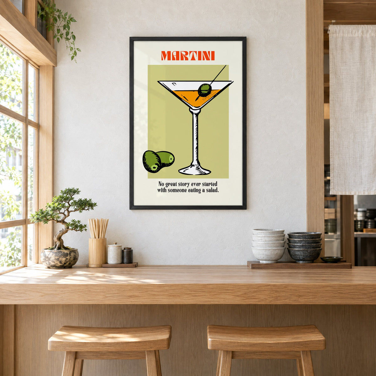 MARTINI sage block olives cocktail print in a black frame above a light wood ramen counter with stools and stacked bowls