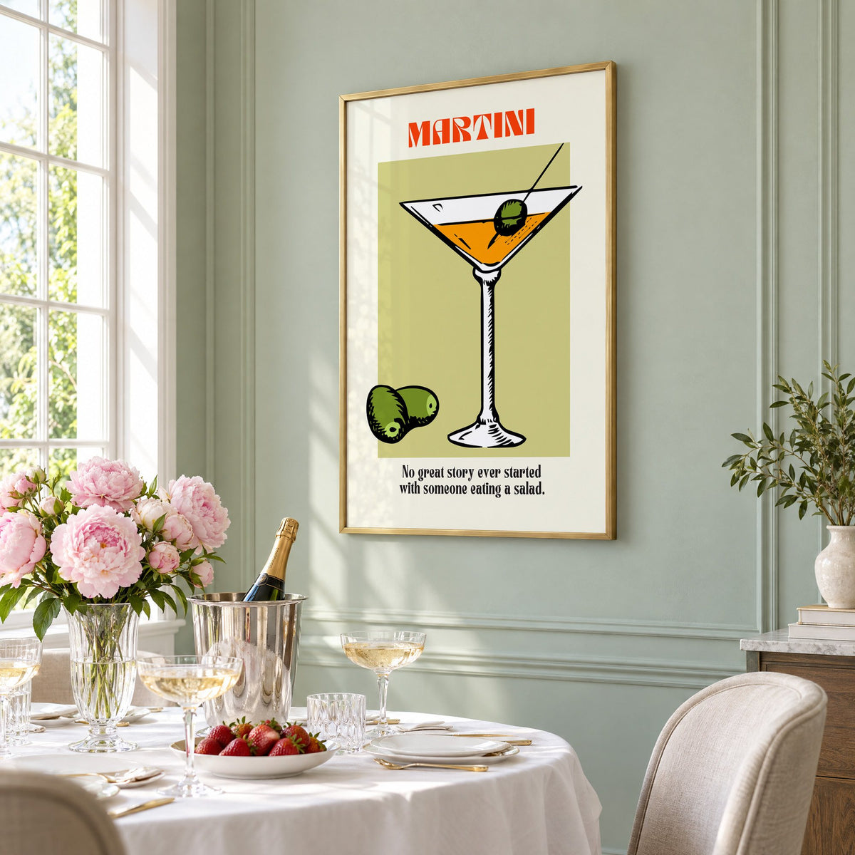 MARTINI sage block olives cocktail print in a brass frame on a sage wall above a brunch table with champagne and peonies, seen at an angle