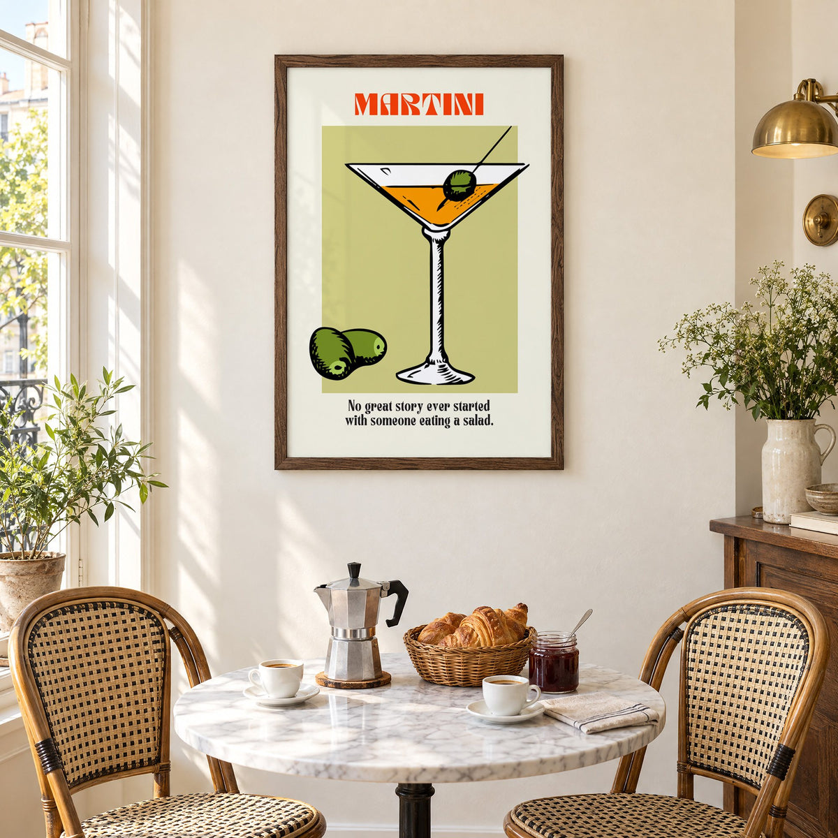 MARTINI sage block olives cocktail print in a walnut frame above a marble bistro table with croissants and rattan chairs