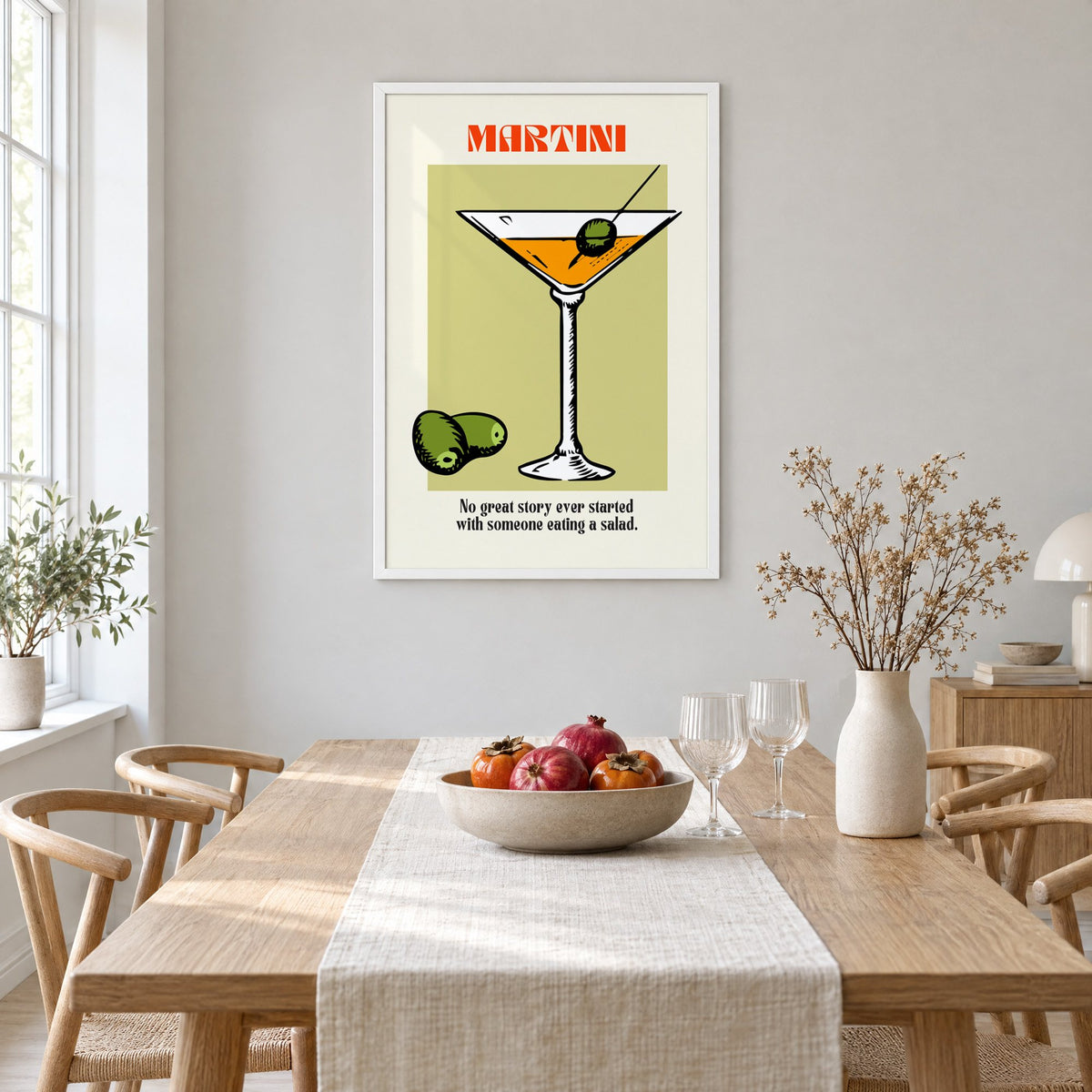 MARTINI sage block olives cocktail print in a white frame above a light oak dining table with a linen runner and fruit bowl