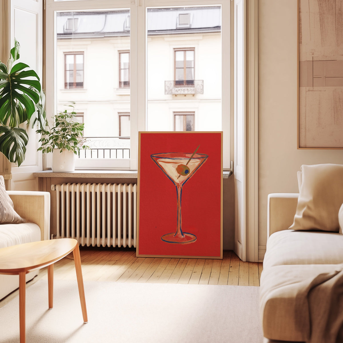 Martini glass wall art print in an oak frame leaning below tall French windows