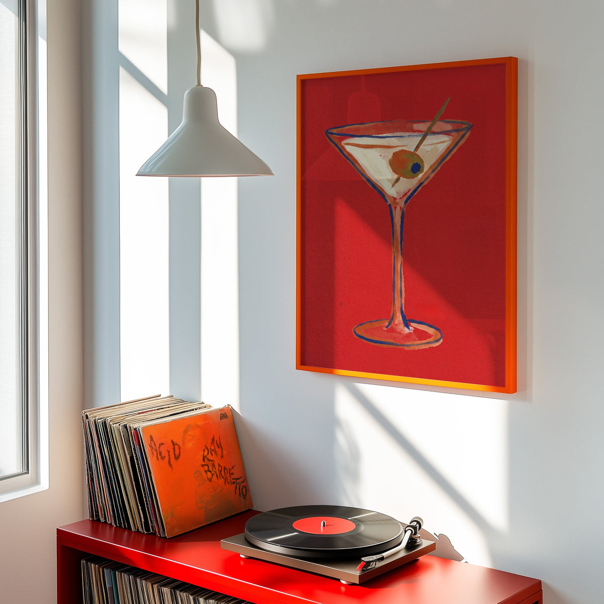 Martini glass wall art print shown in an orange frame above a red record cabinet and turntable