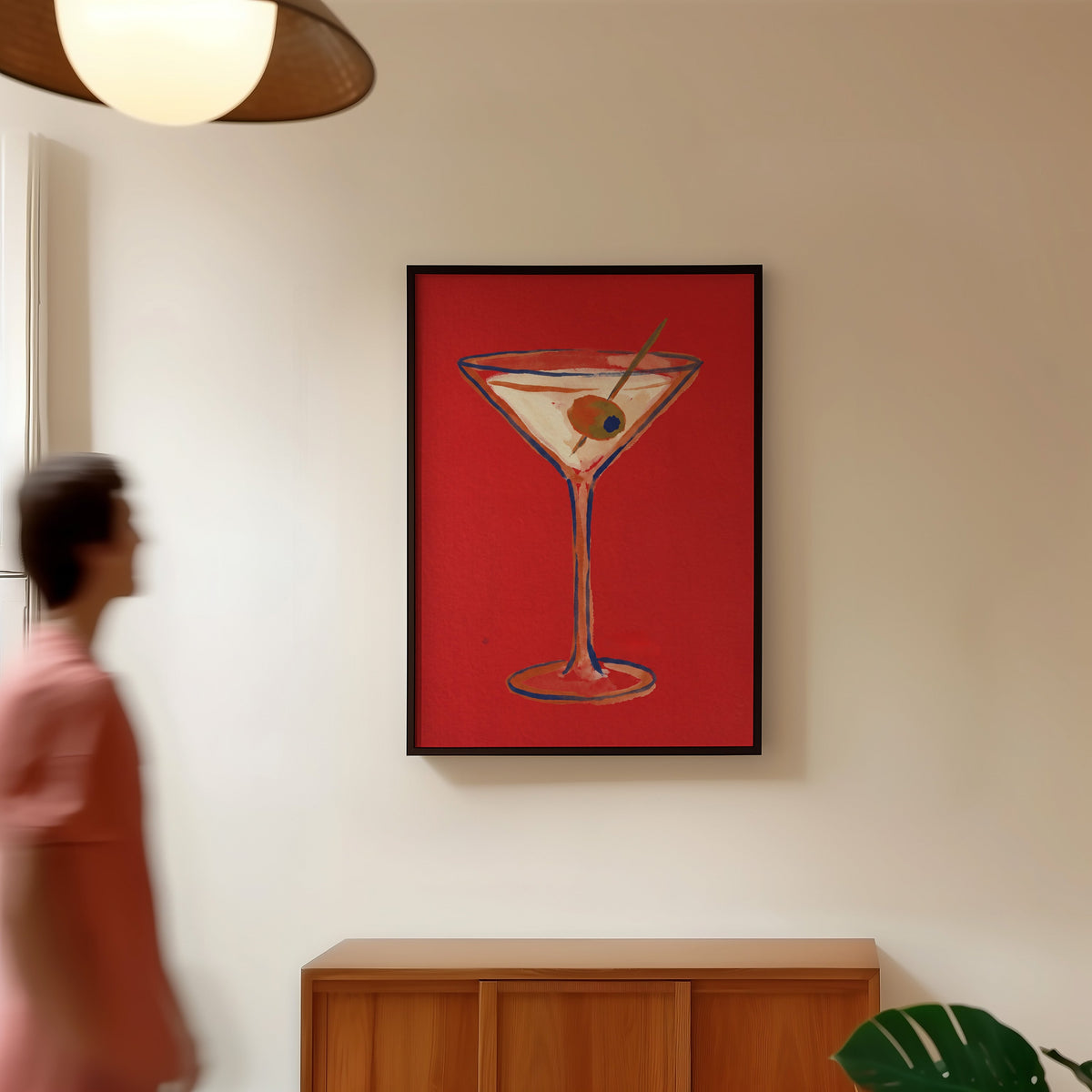 Bar cart martini print in a black frame in a hallway under a rattan pendant