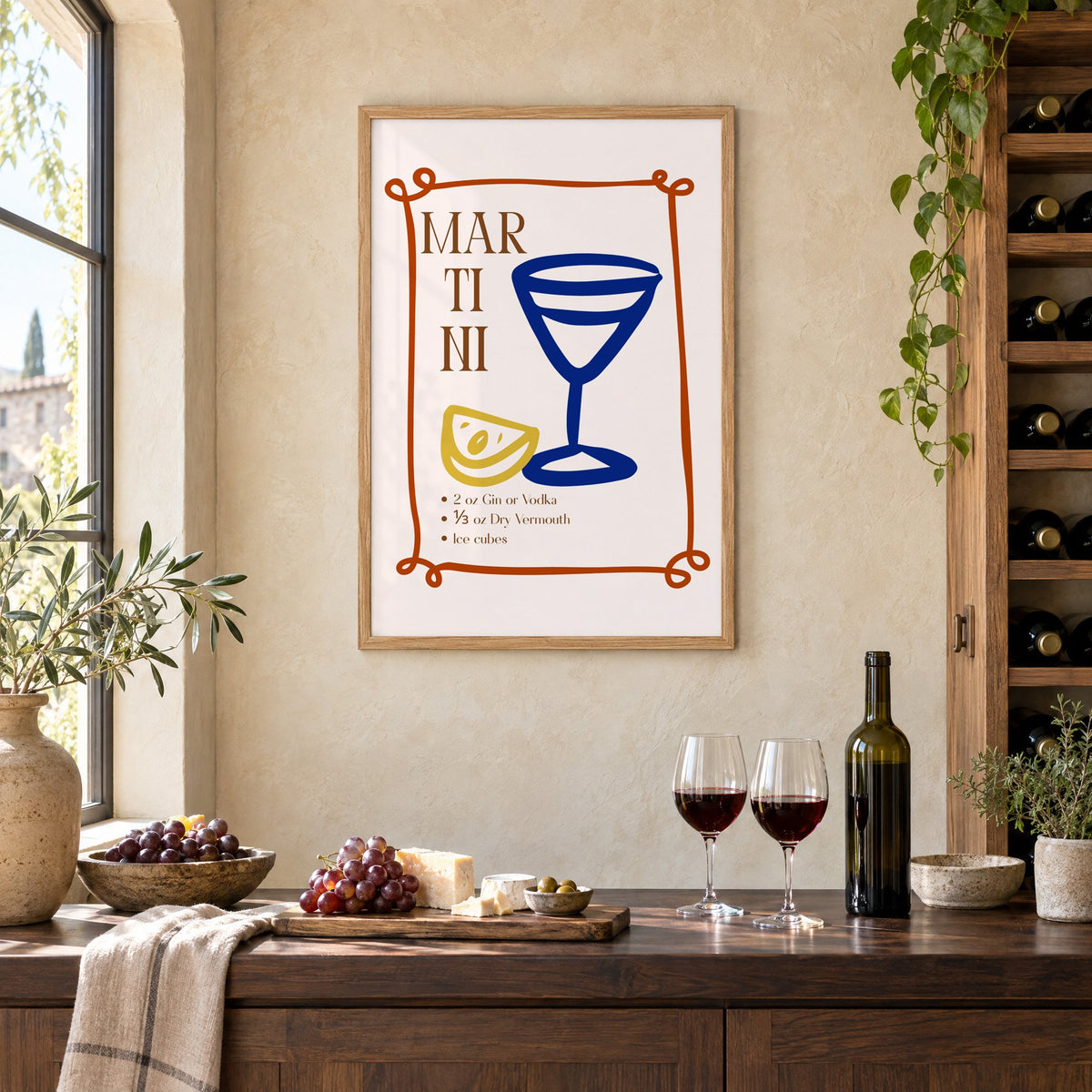 MARTINI recipe navy glass lemon print in an oak frame on a limewashed wall above a wine counter with red wine, cheese and grapes